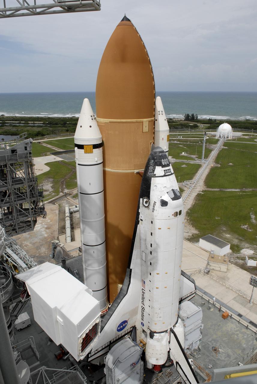 CAPE CANAVERAL, Fla. – Space shuttle Atlantis comes to a stop on the top of Launch Pad 39A at NASA's Kennedy Space Center after more than a 6-hour journey from the Vehicle Assembly Building. First motion occurred at 9:19 a.m. EDT and Atlantis was hard down on the pad at 3:52 p.m. At lower left is the White Room at the end of the orbiter access arm on the fixed service structure. The shuttle stack, with solid rocket boosters and external fuel tank attached to Atlantis, rest on the mobile launcher platform. Movement is provided by the crawler-transporter underneath. The Sept. 2 rollout date was postponed due to Tropical Storm Hanna’s shift to a northern track. Atlantis is scheduled to launch on the STS-125 mission to service NASA’s Hubble Space Telescope. Launch is targeted for Oct. 8. Photo credit: NASA/Kim Shiflett