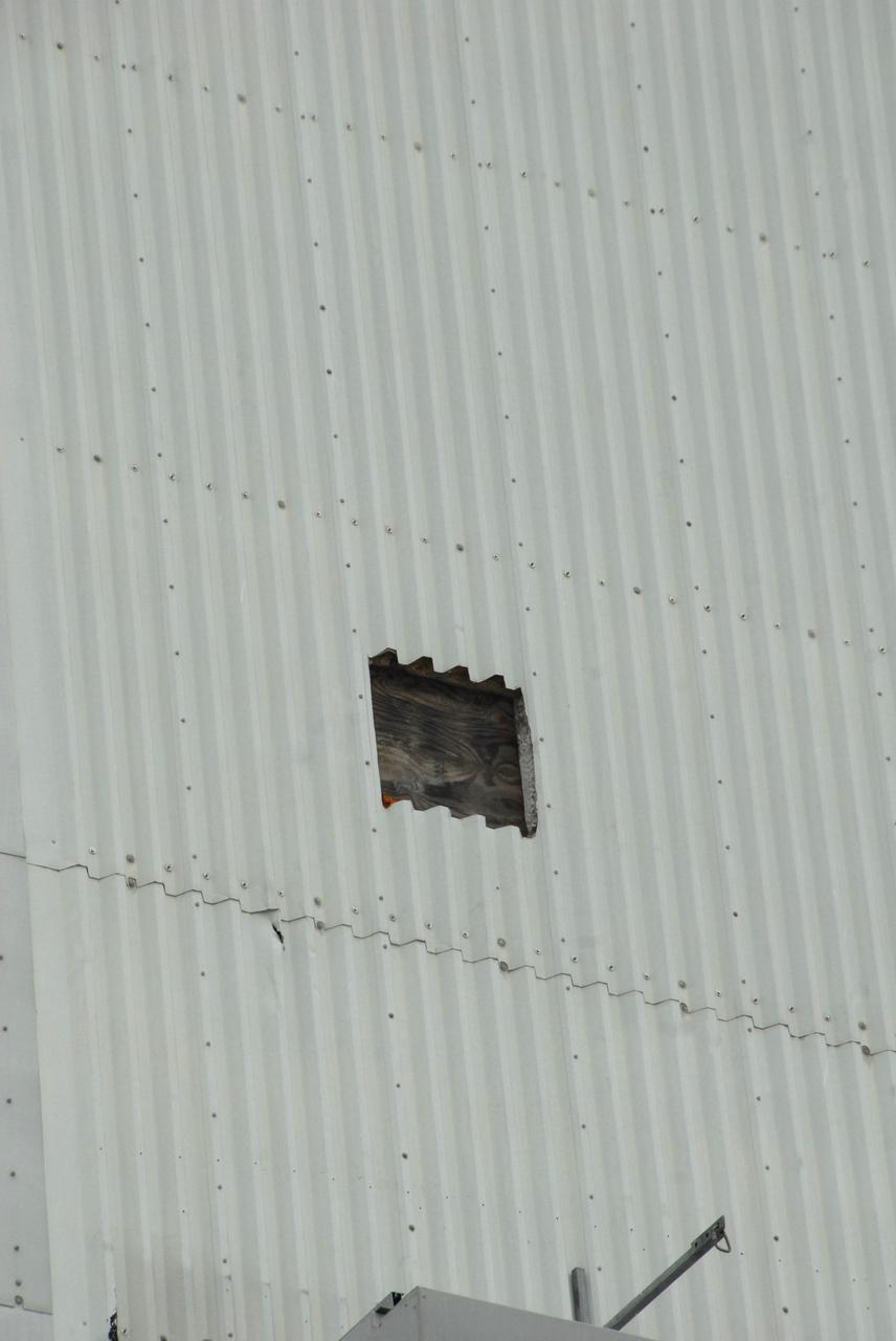 CAPE CANAVERAL, Fla. –  A minor effect of Tropical Storm Hanna as it passed Florida’s east coast, part of a panel on the Vehicle Assembly Building at NASA's Kennedy Space Center came off in a burst of high wind, causing minor damage to a UHF antenna on the roof of the Launch Control Center.  The panel is on the southeast corner of the VAB. Hanna kept well offshore, bearing only bursts of rain and wind along the coastline as it moved north.   Photo credit: NASA/Jack Pfaller