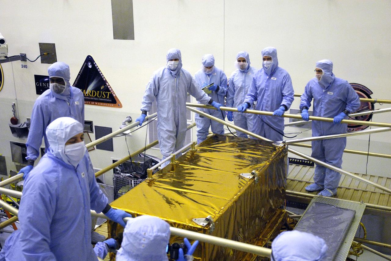 CAPE CANAVERAL, Fla. –  In the Payload Hazardous Servicing Facility at NASA’s Kennedy Space Center, crew members with the STS-125 mission get a close look at some of the equipment associated with their mission to service NASA’s Hubble Space Telescope.  Getting ready to open the Axial Science Instrument Protective Enclosure, or ASIPE, from the back of the stand are a an HST inspector, a technician, Johnson Space Center EVA Trainers Kristie Hansen and Thomas Gonzales Torres, and Mission Specialist Michael Good.  Mission Specialist Mike Massimino is in the foreground at left. The ASIPE contains the Advanced Camera for Surveys.  The STS-125 crew is taking part in a crew equipment interface test, which provides experience handling tools, equipment and hardware they will use on their mission.  Space shuttle Atlantis is targeted to launch on the STS-125 mission Oct. 10. Photo credit: NASA/Kim Shiflett