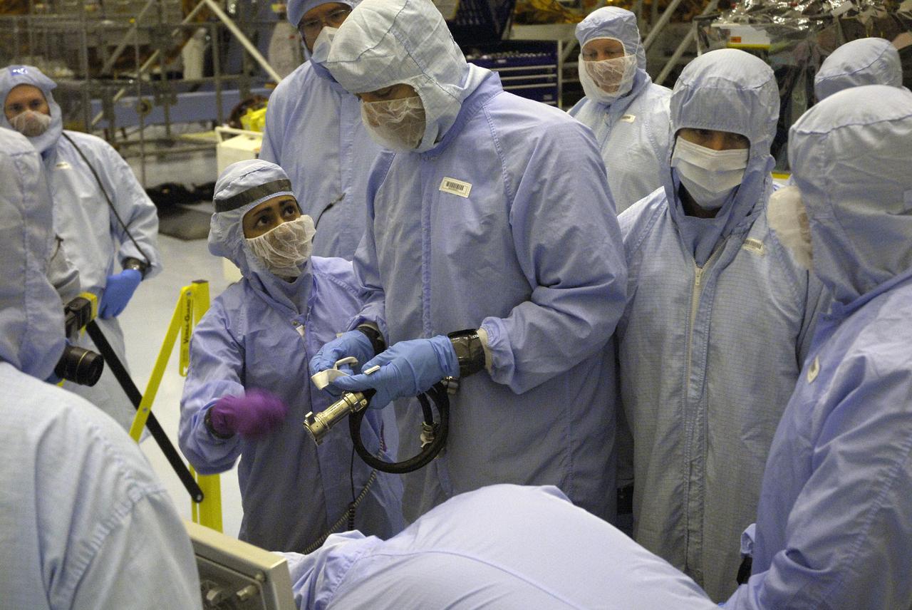 CAPE CANAVERAL, Fla. –   In the Payload Hazardous Servicing Facility at NASA’s Kennedy Space Center, crew members with the STS-125 mission get a close look at some of the equipment associated with their mission to service NASA’s Hubble Space Telescope. At center, HST inspector Minal Kaskhari talks to Mission Specialist Mike Massimino, holding a tool from the Small ORU Protective Enclosure, or SOPE.  On the right are Mission Specialists Andrew Feustel and Michael Good.  The STS-125 crew is taking part in a crew equipment interface test, which provides experience handling tools, equipment and hardware they will use on their mission.  Space shuttle Atlantis is targeted to launch on the STS-125 mission Oct. 10. Photo credit: NASA/Kim Shiflett
