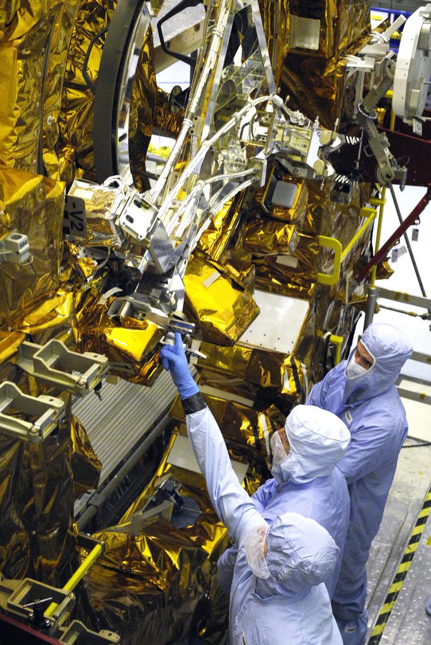 CAPE CANAVERAL, Fla. – In the Payload Hazardous Servicing Facility at NASA’s Kennedy Space Center, crew members with the STS-125 mission get a close look at some of the equipment associated with their mission to service NASA’s Hubble Space Telescope. Looking at the Soft Capture Mechanism on the Flight Support Structure are a technician (pointing) and Mission Specialists Mike Massimino and Michael Good. The mechanism will enable the future rendezvous, capture and safe disposal of NASA's Hubble Space Telescope by either a crewed or robotic mission. The ring-like device attaches to Hubble’s aft bulkhead. The STS-125 crew is taking part in a crew equipment interface test, which provides experience handling tools, equipment and hardware they will use on their mission. Space shuttle Atlantis is targeted to launch on the STS-125 mission Oct. 10. Photo credit: NASA/Kim Shiflett