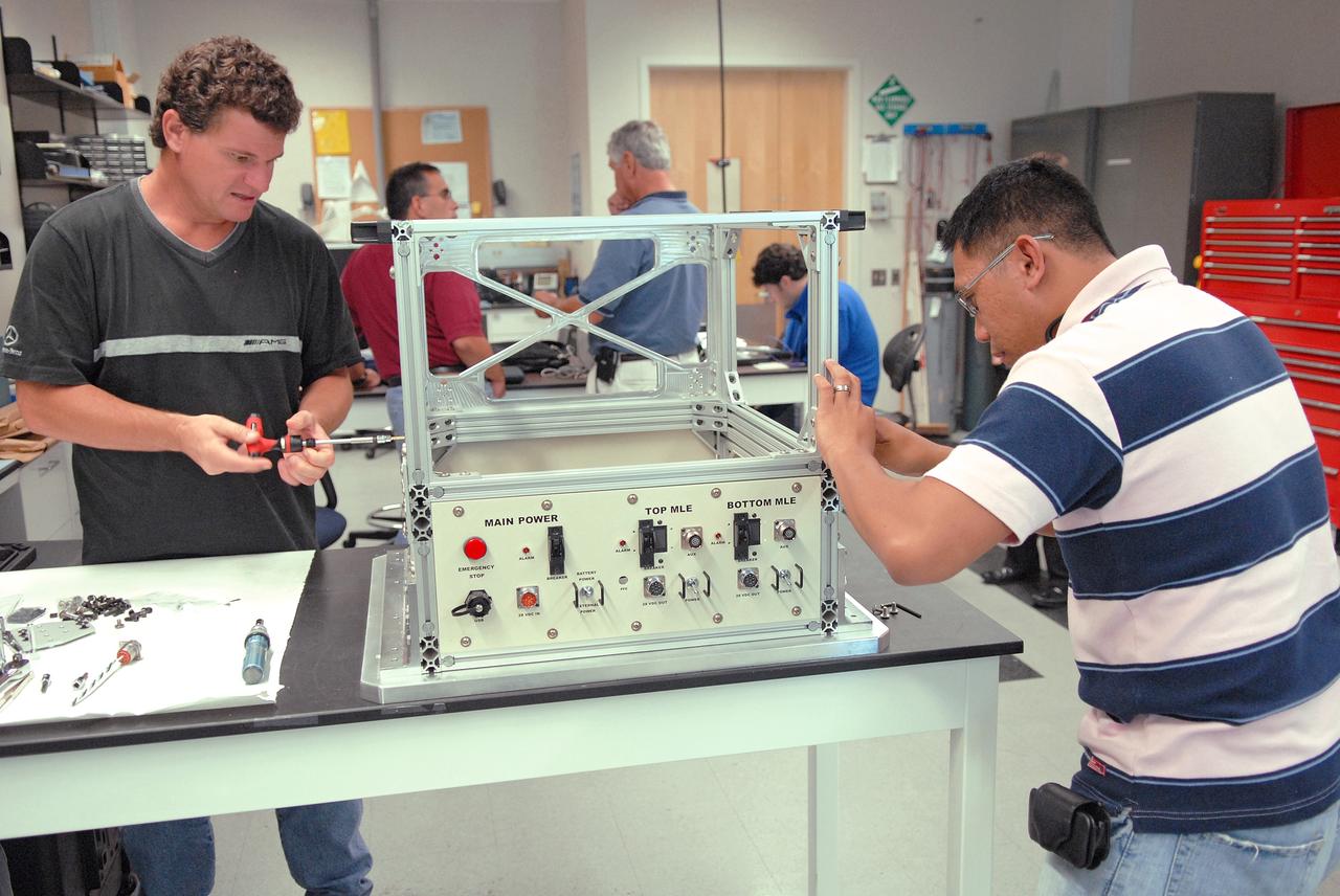 CAPE CANAVERAL, Fla. – Technicians in the Life Science Building at NASA's Kennedy Space Center work on the FASTRACK Space Experiment Platform. The rack is designed to support two standard lockers that fit inside the space shuttle's crew middeck. It is being developed jointly by Kennedy and Space Florida to facilitate NASA and commercial use of reusable U.S. suborbital flight vehicles currently under development. FASTRACK will enable investigators to test experiments, apparatus and analytical techniques in hardware compatible with the International Space Station, and to perform science that can be carried out during the reduced gravity available for brief periods during aircraft parabolas. Flight testing of the FASTRACK will be performed on four consecutive days between September 9-12 from Ellington Field near NASA's Johnson Space Center, Houston. Photo credit: NASA/Troy Cryder