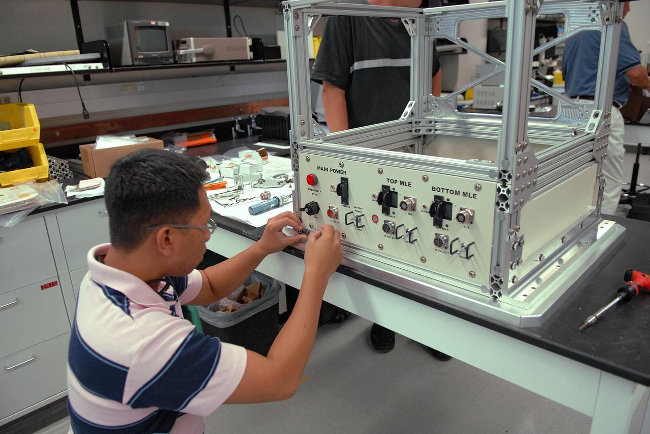 CAPE CANAVERAL, Fla. – A technician in the Life Science Building at NASA's Kennedy Space Center works on the FASTRACK Space Experiment Platform. The rack is designed to support two standard lockers that fit inside the space shuttle's crew middeck. It is being developed jointly by Kennedy and Space Florida to facilitate NASA and commercial use of reusable U.S. suborbital flight vehicles currently under development. FASTRACK will enable investigators to test experiments, apparatus and analytical techniques in hardware compatible with the International Space Station, and to perform science that can be carried out during the reduced gravity available for brief periods during aircraft parabolas. Flight testing of the FASTRACK will be performed on four consecutive days between September 9-12 from Ellington Field near NASA's Johnson Space Center, Houston. Photo credit: NASA/Troy Cryder
