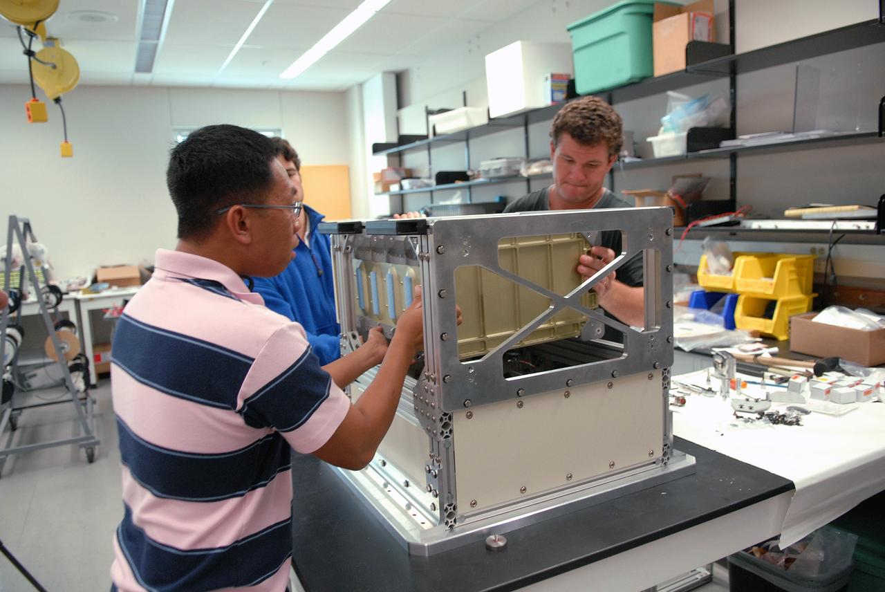 CAPE CANAVERAL, Fla. – Technicians in the Life Science Building at NASA's Kennedy Space Center work on the FASTRACK Space Experiment Platform. The rack is designed to support two standard lockers that fit inside the space shuttle's crew middeck. It is being developed jointly by Kennedy and Space Florida to facilitate NASA and commercial use of reusable U.S. suborbital flight vehicles currently under development. FASTRACK will enable investigators to test experiments, apparatus and analytical techniques in hardware compatible with the International Space Station, and to perform science that can be carried out during the reduced gravity available for brief periods during aircraft parabolas. Flight testing of the FASTRACK will be performed on four consecutive days between September 9-12 from Ellington Field near NASA's Johnson Space Center, Houston. Photo credit: NASA/Troy Cryder