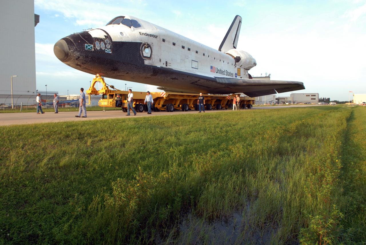 CAPE CANAVERAL, Fla. – Workers accompany space shuttle Endeavour as it rolls toward the Vehicle Assembly Building at NASA's Kennedy Space Center. The shuttle left Orbiter Processing Facility 2 with first motion at 7:01 am. EDT. In the VAB, Endeavour will be attached to its external fuel tank and twin solid rocket boosters. After additional preparations are made, the shuttle will be rolled out to Launch Pad 39B. Endeavour is the backup shuttle, if needed for rescue, for space shuttle Atlantis’ STS-125 mission to NASA’s Hubble Space Telescope targeted for October. Photo credit: NASA/Troy Cryder