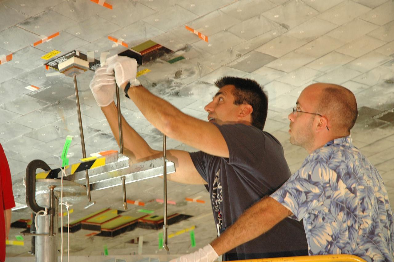 CAPE CANAVERAL, Fla. - In Orbiter Processing Facility 3 at NASA's Kennedy Space Center, a technician makes a fit check of boundary layer transition tile underneath space shuttle Discovery. Scheduled to launch on the STS-119 mission, Discovery will carry the S6 truss segment to complete the 361-foot-long backbone of the International Space Station. The truss includes the fourth pair of solar array wings and electronics that convert sunlight to power for the orbiting laboratory. Discovery is targeted to launch Feb. 12, 2009. Photo credit: NASA/Jim Grossmann