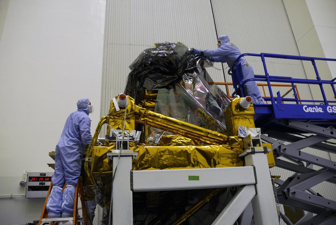 CAPE CANAVERAL, Fla. - In the Payload Hazardous Servicing Facility at NASA's Kennedy Space Center, a technician uncovers the Super Lightweight Interchangeable Carrier, or SLIC. Contamination discovered Sept. 17 during preparations to deliver NASA's Hubble Space Telescope servicing payload to Launch Pad 39A will be removed. Cleanliness is extremely important for space shuttle Atlantis’ STS-125 mission to Hubble, and the teams have insured that the SLIC is ready to fly. The SLIC, which holds battery module assemblies for servicing of the Hubble Space Telescope on the STS-125 mission, is built with state-of-the-art, lightweight, composite materials - carbon fiber with a cyanate ester resin and a titanium metal matrix composite. These composites have greater strength-to-mass ratios than the metals typically used in spacecraft design. The carrier is one of four being transferred to Launch Pad 39A. At the pad, the carriers will be loaded into Atlantis’ payload bay. Launch of Atlantis is targeted for Oct. 10. Photo credit: NASA/Jack Pfaller