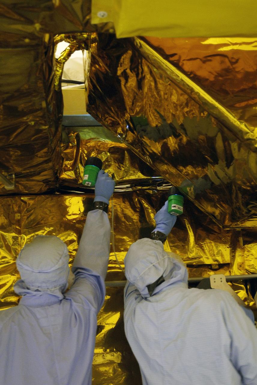 CAPE CANAVERAL, Fla. - In the Payload Hazardous Servicing Facility at NASA's Kennedy Space Center, technicians inspect areas of the Super Lightweight Interchangeable Carrier, or SLIC, for contamination. Contamination discovered Sept. 17 during preparations to deliver NASA's Hubble Space Telescope servicing payload to Launch Pad 39A will be removed. Cleanliness is extremely important for space shuttle Atlantis’ STS-125 mission to Hubble, and the teams have insured that the SLIC is ready to fly. The SLIC, which holds battery module assemblies for servicing of the Hubble Space Telescope on the STS-125 mission, is built with state-of-the-art, lightweight, composite materials - carbon fiber with a cyanate ester resin and a titanium metal matrix composite. These composites have greater strength-to-mass ratios than the metals typically used in spacecraft design. The carrier is one of four being transferred to Launch Pad 39A. At the pad, the carriers will be loaded into Atlantis’ payload bay. Launch of Atlantis is targeted for Oct. 10. Photo credit: NASA/Jack Pfaller