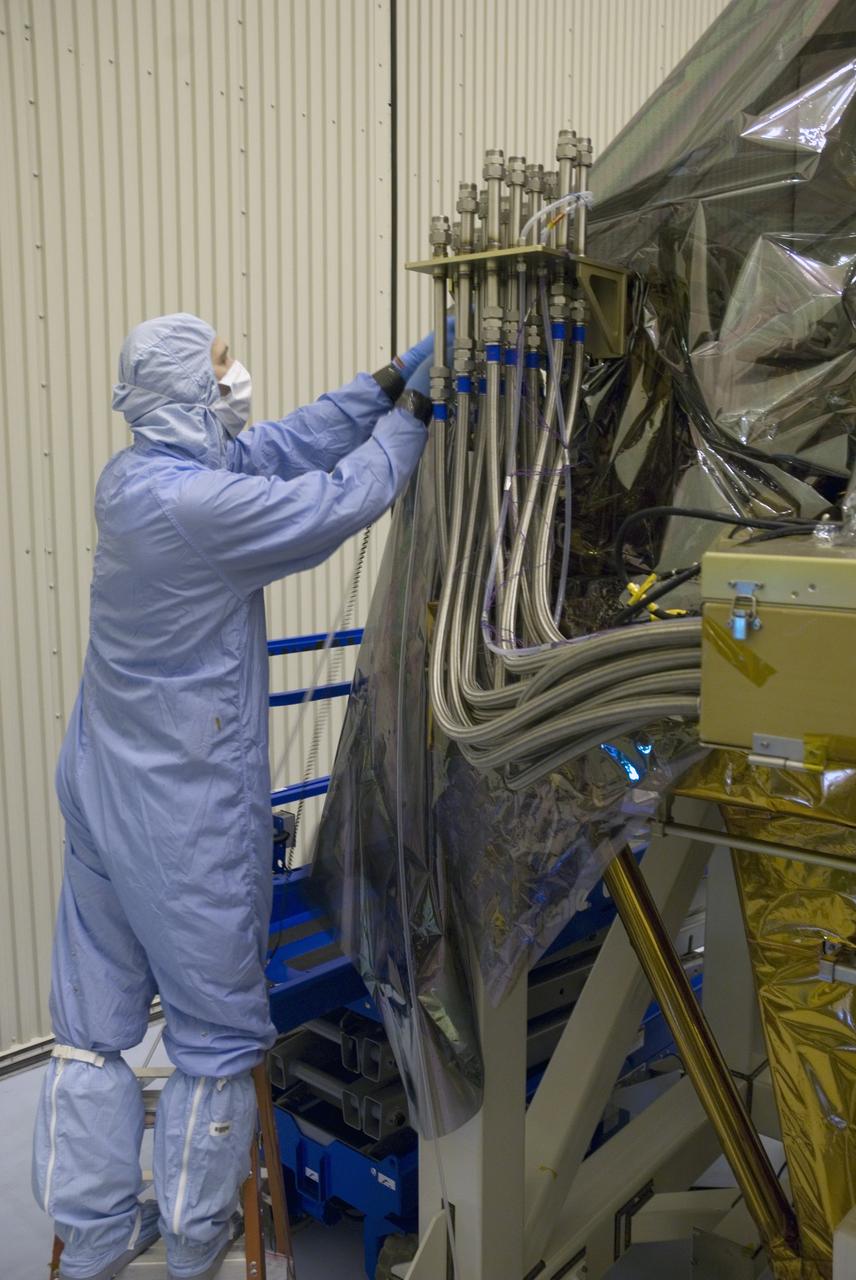 CAPE CANAVERAL, Fla. - In the Payload Hazardous Servicing Facility at NASA's Kennedy Space Center, a technician works to replace the protective cover on the Super Lightweight Interchangeable Carrier, or SLIC. The cover was removed to clean the carrier of contaminants found Sept. 17 during preparations to deliver NASA's Hubble Space Telescope servicing payload to Launch Pad 39A. Cleanliness is extremely important for space shuttle Atlantis’ STS-125 mission to Hubble, and the teams have insured that the SLIC is ready to fly. The SLIC, which holds battery module assemblies, is built with state-of-the-art, lightweight, composite materials - carbon fiber with a cyanate ester resin and a titanium metal matrix composite. These composites have greater strength-to-mass ratios than the metals typically used in spacecraft design. The carrier is one of four being transferred to Launch Pad 39A. At the pad, the carriers will be loaded into Atlantis’ payload bay. Launch of Atlantis is targeted for Oct. 10. Photo credit: NASA/Jack Pfaller