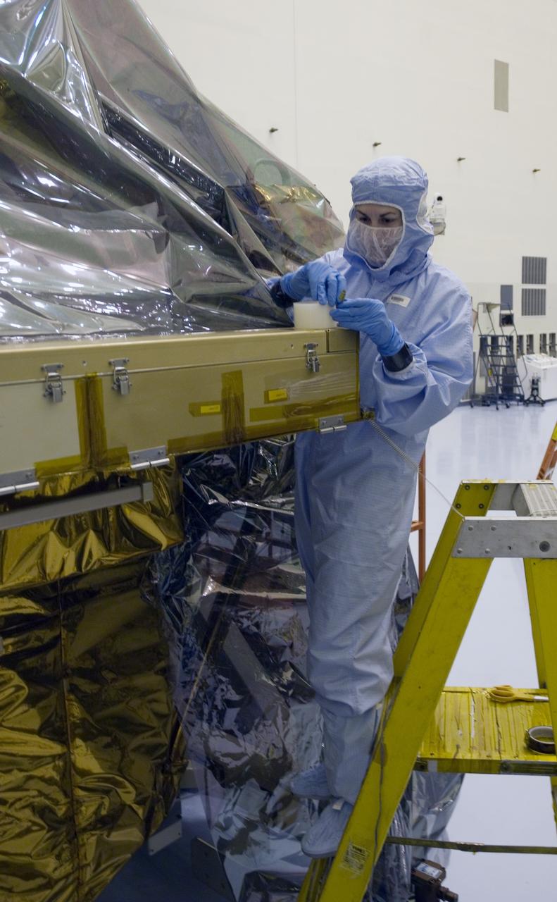 CAPE CANAVERAL, Fla. - In the Payload Hazardous Servicing Facility at NASA's Kennedy Space Center, a technician works to replace the protective cover on the Super Lightweight Interchangeable Carrier, or SLIC. The cover was removed to clean the carrier of contaminants found Sept. 17 during preparations to deliver NASA's Hubble Space Telescope servicing payload to Launch Pad 39A. Cleanliness is extremely important for space shuttle Atlantis’ STS-125 mission to Hubble, and the teams have insured that the SLIC is ready to fly. The SLIC, which holds battery module assemblies, is built with state-of-the-art, lightweight, composite materials - carbon fiber with a cyanate ester resin and a titanium metal matrix composite. These composites have greater strength-to-mass ratios than the metals typically used in spacecraft design. The carrier is one of four being transferred to Launch Pad 39A. At the pad, the carriers will be loaded into Atlantis’ payload bay. Launch of Atlantis is targeted for Oct. 10. Photo credit: NASA/Jack Pfaller