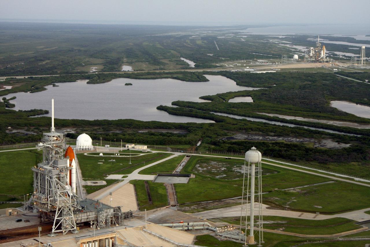 CAPE CANAVERAL, Fla. - An aerial view of the Launch Complex at NASA's Kennedy Space Center shows space shuttles on both pads. At upper right is space shuttle Endeavour, which rolled out Sept. 19, completing the 4.2-mile journey at 6:59 a.m. EDT. In the foreground is space shuttle Atlantis, preparing for its launch on the STS-125 mission to repair NASA's Hubble Space Telescope, targeted for Oct. 10. This is the first time since July 2001 that two shuttles are on the launch pads at the same time at the center. Endeavour will stand by at pad B in the unlikely event that a rescue mission is necessary during space shuttle Atlantis' upcoming mission. After Endeavour is cleared from its duty as a rescue spacecraft, it will be moved to Launch Pad 39A for the STS-126 mission to the International Space Station. That flight is targeted for launch Nov. 12. Photo credit: NASA/Troy Cryder