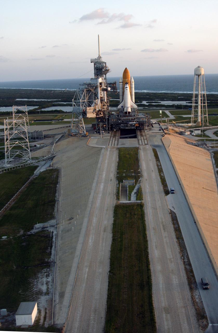 CAPE CANAVERAL, Fla. -   Space shuttle Endeavour is viewed from the air on Launch Pad 39B after the rollout from the Vehicle Assembly Building at NASA's Kennedy Space Center.  At left of the shuttle is the open rotating service structure and the fixed service structure with the 80-foot lightning mast on top. First motion out of the Vehicle Assembly Building was at 11:15 p.m. Sept. 18. In the background is the Atlantic Ocean. At right is the tower that holds 300,000 gallons of water used for sound suppression on the pad during liftoff.  Endeavour completed the 4.2-mile journey at 6:59 a.m. EDT. For the first time since July 2001, two shuttles are on the launch pads at the same time at the center. Endeavour will stand by at pad B in the unlikely event that a rescue mission is necessary during space shuttle Atlantis' upcoming mission to repair NASA's Hubble Space Telescope, targeted to launch Oct. 10. After Endeavour is cleared from its duty as a rescue spacecraft, it will be moved to Launch Pad 39A for the STS-126 mission to the International Space Station. That flight is targeted for launch Nov. 12. Photo credit: NASA/Troy Cryder