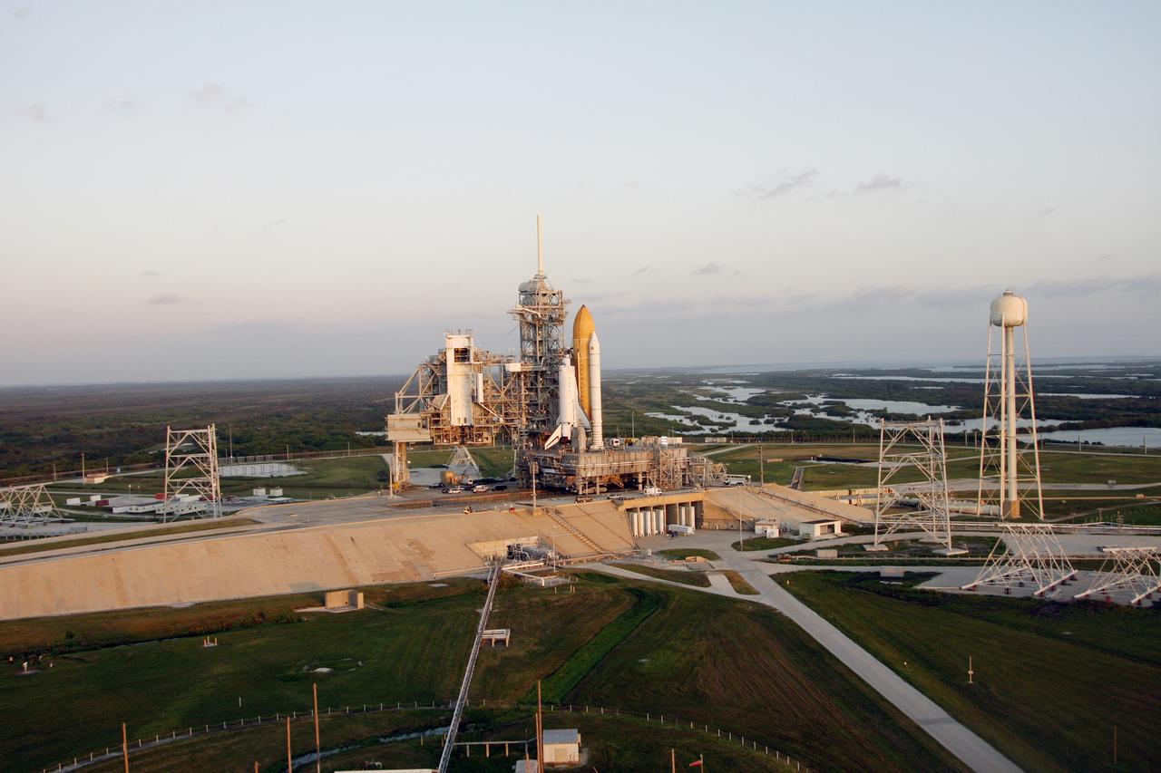CAPE CANAVERAL, Fla. -   Space shuttle Endeavour is viewed from the air on Launch Pad 39B after the rollout from the Vehicle Assembly Building at NASA's Kennedy Space Center.  At left of the shuttle is the open rotating service structure and the fixed service structure with the 80-foot lightning mast on top. Far on the horizon is the Atlantic Ocean. At right is the tower that holds 300,000 gallons of water used for sound suppression on the pad during liftoff. First motion out of the Vehicle Assembly Building was at 11:15 p.m. Sept. 18.  Endeavour completed the 4.2-mile journey at 6:59 a.m. EDT. For the first time since July 2001, two shuttles are on the launch pads at the same time at the center. Endeavour will stand by at pad B in the unlikely event that a rescue mission is necessary during space shuttle Atlantis' upcoming mission to repair NASA's Hubble Space Telescope, targeted to launch Oct. 10. After Endeavour is cleared from its duty as a rescue spacecraft, it will be moved to Launch Pad 39A for the STS-126 mission to the International Space Station. That flight is targeted for launch Nov. 12. Photo credit: NASA/Troy Cryder