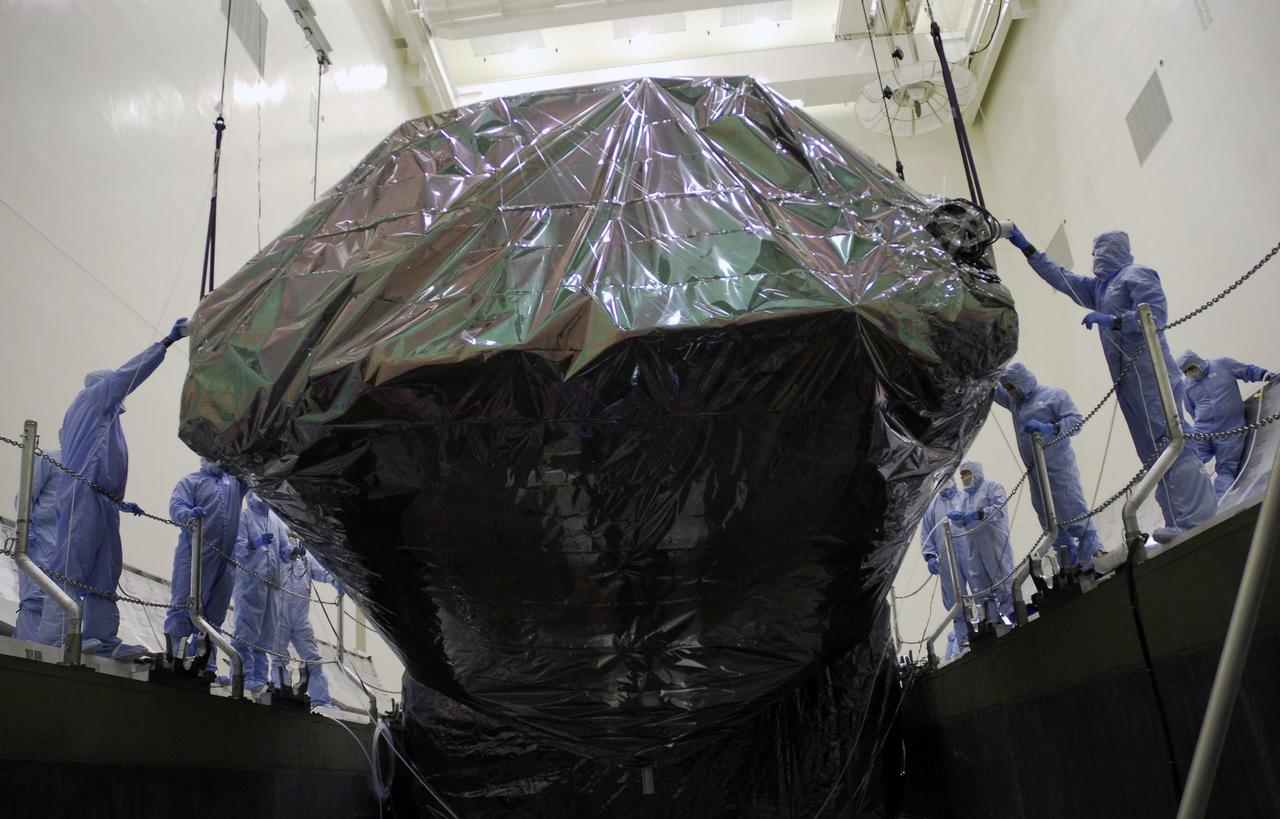 CAPE CANAVERAL, Fla. -  In the Payload Hazardous Servicing Facility at NASA's Kennedy Space Center, an overhead crane lowers the Super Lightweight Interchangeable Carrier, or SLIC, into the payload canister. The SLIC, one of four carriers associated with the STS-125 mission to service the Hubble Space Telescope, will be moved to Launch Pad 39A.  At the pad, all the carriers will be loaded into space shuttle Atlantis’ payload bay. Launch of Atlantis is targeted for Oct. 10.  Photo credit: NASA/Jack Pfaller