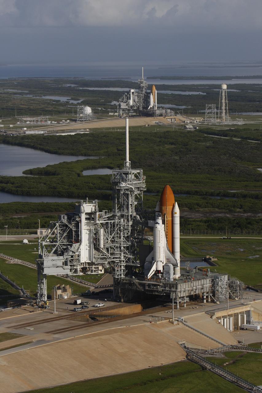 CAPE CANAVERAL, Fla. - Space shuttle Atlantis (foreground) sits on Launch Pad A and Endeavour on Launch Pad B at NASA’s Kennedy Space Center in Florida. At the left of each shuttle are the open rotating service structures with the payload changeout rooms revealed. The rotating service structures provide protection for weather and access to the shuttle. For the first time since July 2001, two shuttles are on the launch pads at the same time at the center. Endeavour will stand by at pad B in the unlikely event that a rescue mission is necessary during space shuttle Atlantis’ upcoming mission to repair NASA’s Hubble Space Telescope, targeted to launch Oct. 10. After Endeavour is cleared from its duty as a rescue spacecraft, it will be moved to Launch Pad 39A for its STS-126 mission to the International Space Station. That flight is targeted for launch Nov. 12. Photo credit: NASA/Troy Cryder