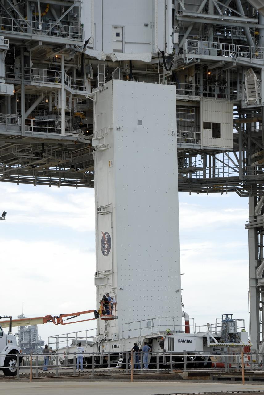 CAPE CANAVERAL, Fla. -  At Launch Pad 39A at NASA’s Kennedy Space Center in Florida, technicians work to move the Hubble payload canister into the payload changeout room for space shuttle Atlantis’ STS-125 mission.  The canister arrived at the pad on Saturday evening, however, early Sunday morning technicians were unable to place the canister into the pad’s payload changeout room. Teflon pads on “shoes” attached to the outside of the payload canister that help the canister move along guide rails didn’t fit properly. The shoes were removed and several options were considered, including slightly shaving down the pads so the shoes will fit onto the rails.  STS-125 is the fifth and final shuttle Hubble Space Telescope servicing mission. Atlantis’ launch is targeted for Oct. 10. Photo credit: NASA/Kim Shiflett.