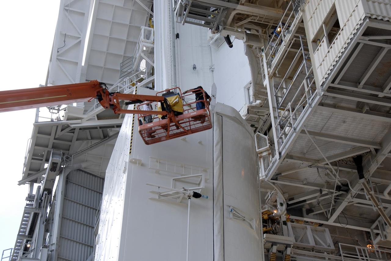 CAPE CANAVERAL, Fla. -  At Launch Pad 39A at NASA’s Kennedy Space Center in Florida, technicians work to move the Hubble payload canister into the payload changeout room for space shuttle Atlantis’ STS-125 mission.  The canister arrived at the pad on Saturday evening; however, early Sunday morning technicians were unable to place the canister into the pad’s payload changeout room. Teflon pads on “shoes” attached to the outside of the payload canister that help the canister move along the guide rails didn’t fit properly. The shoes were removed and several options were considered, including slightly shaving down the pads so the shoes will fit onto the rails.  STS-125 is the fifth and final shuttle Hubble Space Telescope servicing mission. Atlantis’ launch is targeted for Oct. 10. Photo credit: NASA/Kim Shiflett.