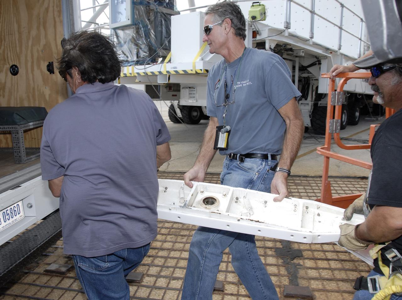 CAPE CANAVERAL, Fla. -  Technicians carry a “shoe” that was removed from the Hubble payload canister at Launch Pad 39A at NASA’s Kennedy Space Center in Florida. The canister arrived at the pad on Saturday evening, however, early Sunday morning technicians were unable to place the canister into the pad’s payload changeout room for space shuttle Atlantis’ STS-125 mission. Teflon pads on “shoes” attached to the outside of the payload canister that help the canister move along the guide rails didn’t fit properly. The shoes were removed and several options were considered, including slightly shaving down the pads so the shoes will fit onto the rails. STS-125 is the fifth and final shuttle Hubble Space Telescope servicing mission. Atlantis’ launch is targeted for Oct. 10. Photo credit: NASA/Kim Shiflett.