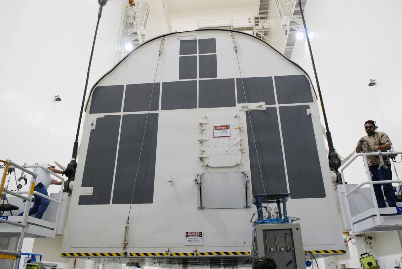 CAPE CANAVERAL, Fla. -   In the Canister Rotation Facility at NASA's Kennedy Space Center, workers check cable fittings that will lift the payload canister to a vertical position for the trip to Launch Pad 39A. The canister’s cargo consists of four carriers holding various equipment for the STS-125 mission aboard space shuttle Atlantis to service NASA’s Hubble Space Telescope.  At the pad, the cargo will be moved into the Payload Changeout Room.  The changeout room is the enclosed, environmentally controlled portion of the rotating service structure that supports cargo delivery to the pad and subsequent vertical installation into the shuttle’s payload bay. Launch of Atlantis is targeted for Oct. 10.   Photo credit: NASA/Jack Pfaller