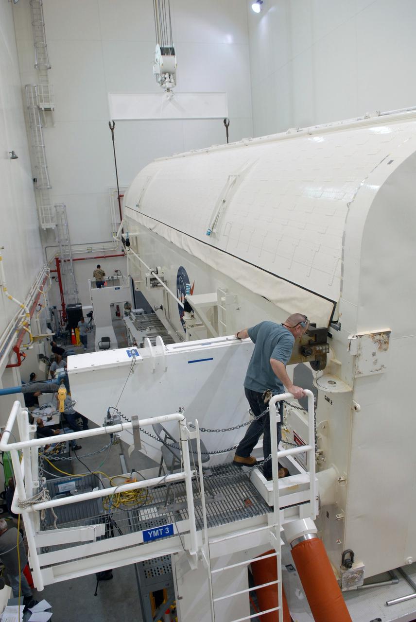 CAPE CANAVERAL, Fla. -  In the Canister Rotation Facility at NASA's Kennedy Space Center, workers get ready to lift the payload canister to a vertical position for the trip to Launch Pad 39A. The canister’s cargo consists of four carriers holding various equipment for the STS-125 mission aboard space shuttle Atlantis to service NASA’s Hubble Space Telescope.  At the pad, the cargo will be moved into the Payload Changeout Room.  The changeout room is the enclosed, environmentally controlled portion of the rotating service structure that supports cargo delivery to the pad and subsequent vertical installation into the shuttle’s payload bay. Launch of Atlantis is targeted for Oct. 10.   Photo credit: NASA/Jack Pfaller
