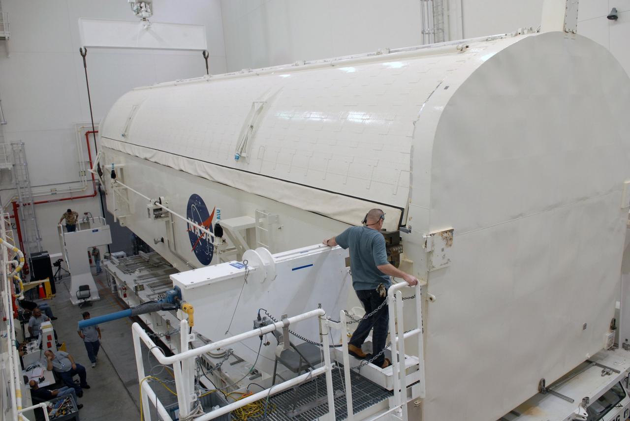 CAPE CANAVERAL, Fla. -  In the Canister Rotation Facility at NASA's Kennedy Space Center, workers get ready to lift the payload canister to a vertical position for the trip to Launch Pad 39A. The canister’s cargo consists of four carriers holding various equipment for the STS-125 mission aboard space shuttle Atlantis to service NASA’s Hubble Space Telescope. At the pad, the cargo will be moved into the Payload Changeout Room.  The changeout room is the enclosed, environmentally controlled portion of the rotating service structure that supports cargo delivery to the pad and subsequent vertical installation into the shuttle’s payload bay. Launch of Atlantis is targeted for Oct. 10.   Photo credit: NASA/Jack Pfaller