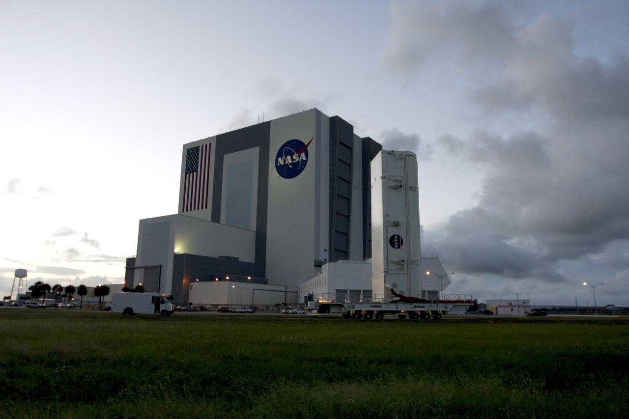 CAPE CANAVERAL, Fla. -  On its way to Launch Pad 39A, the payload canister passes the Vehicle Assembly Building and Launch Control Center at NASA's Kennedy Space Center in Florida.  The canister carries a cargo of four carriers holding various equipment for the STS-125 mission aboard space shuttle Atlantis to service NASA’s Hubble Space Telescope.  At the pad, the cargo will be moved into the Payload Changeout Room.  The changeout room is the enclosed, environmentally controlled portion of the rotating service structure that supports cargo delivery to the pad and subsequent vertical installation into the shuttle’s payload bay. Launch of Atlantis is targeted for Oct. 10.  Photo credit: NASA/Troy Cryder