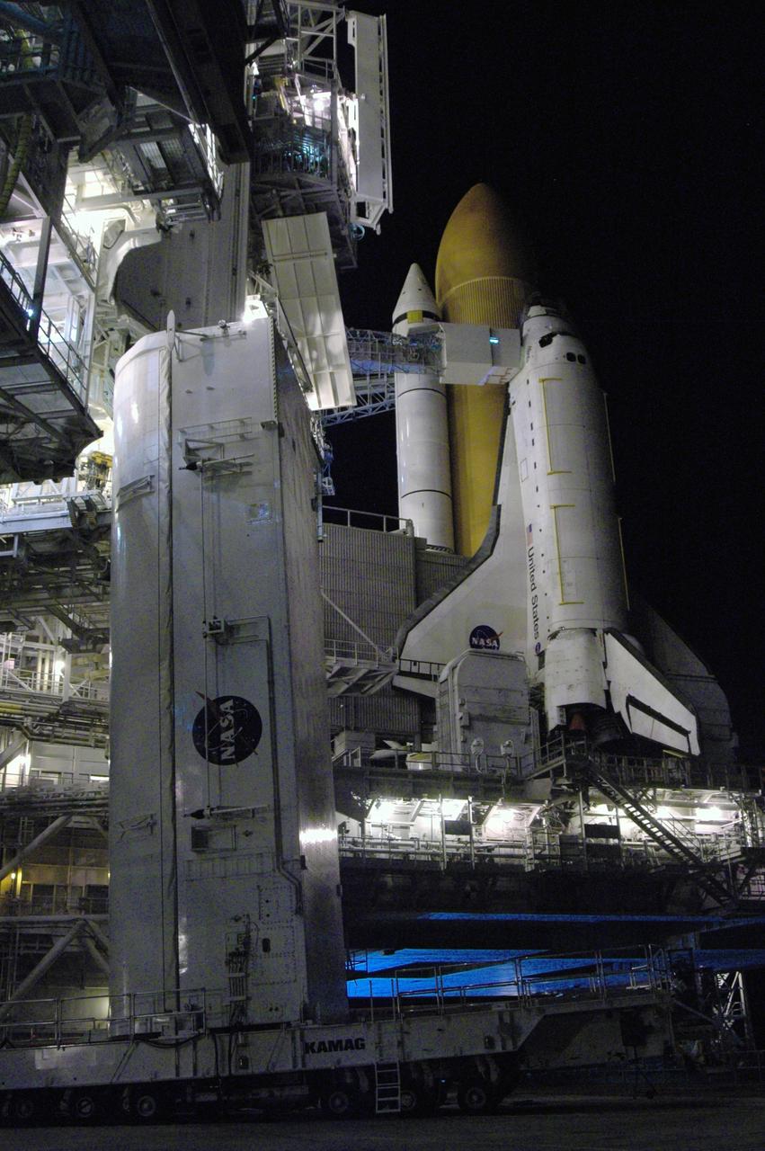 CAPE CANAVERAL, Fla. - On Launch Pad 39A at NASA's Kennedy Space Center, the payload canister waits for adjusted guide shoes to be attached before being lifted to the payload changeout room for the second time. The first attempt encountered problems when Teflon pads on “shoes” attached to the outside of the canister that go onto guide rails to help the canister into the room didn’t fit properly. The two shoes were removed, slightly shaved down so that they would fit into the rails and put back on the canister. The changeout room is the enclosed, environmentally controlled portion of the rotating service structure that supports cargo delivery to the pad and subsequent vertical installation into the shuttle’s payload bay. Launch of Atlantis is targeted for Oct. 10. Photo credit: NASA/Jim Grossmann