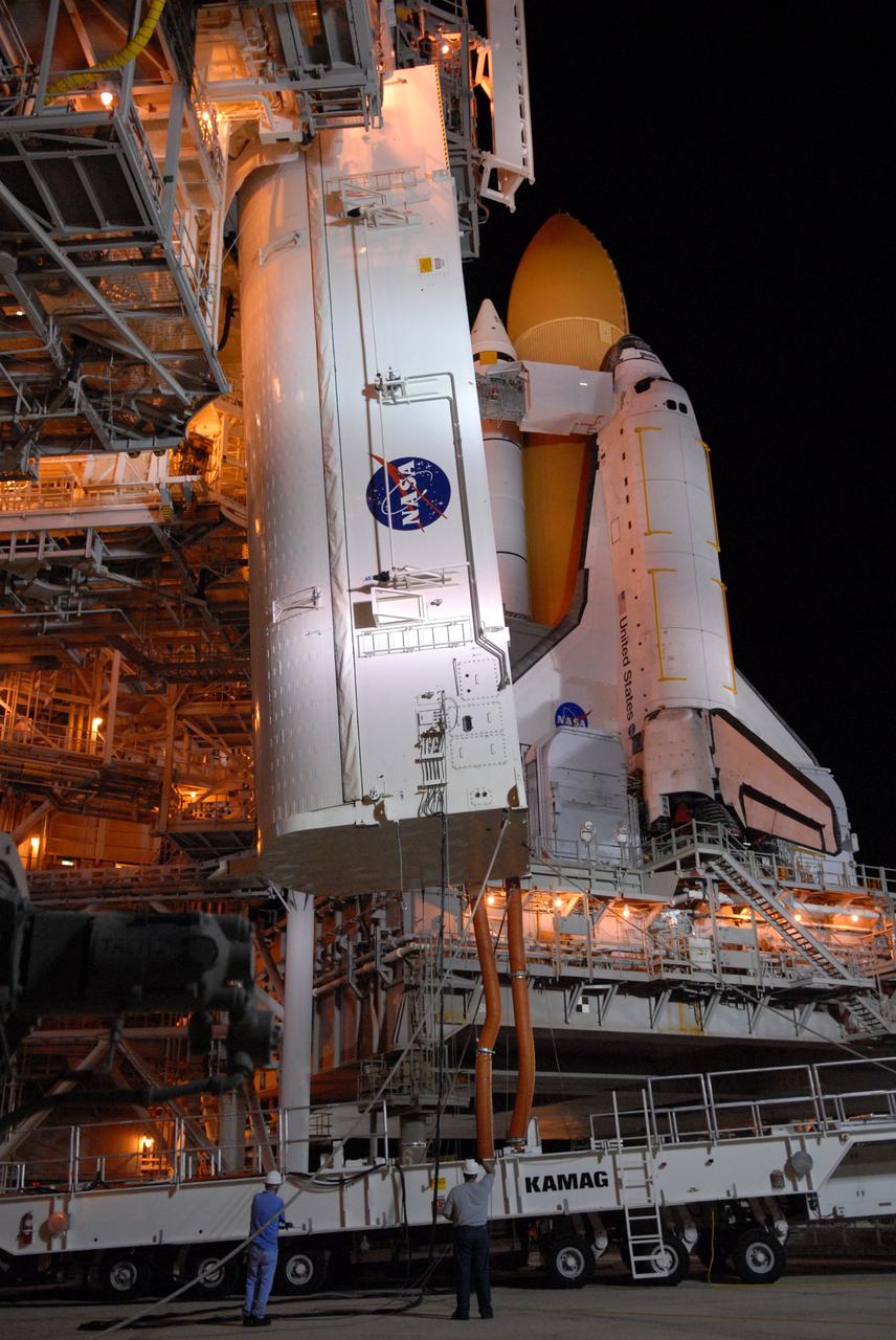 CAPE CANAVERAL, Fla. -  On Launch Pad 39A at NASA's Kennedy Space Center, the payload canister is lifted toward the payload changeout room above.  The canister contains four carriers holding various equipment for the STS-125 mission aboard space shuttle Atlantis to service NASA’s Hubble Space Telescope.  The changeout room is the enclosed, environmentally controlled portion of the rotating service structure that supports cargo delivery to the pad and subsequent vertical installation into the shuttle’s payload bay. Launch of Atlantis is targeted for Oct. 10.   Photo credit: NASA/Jack Pfaller