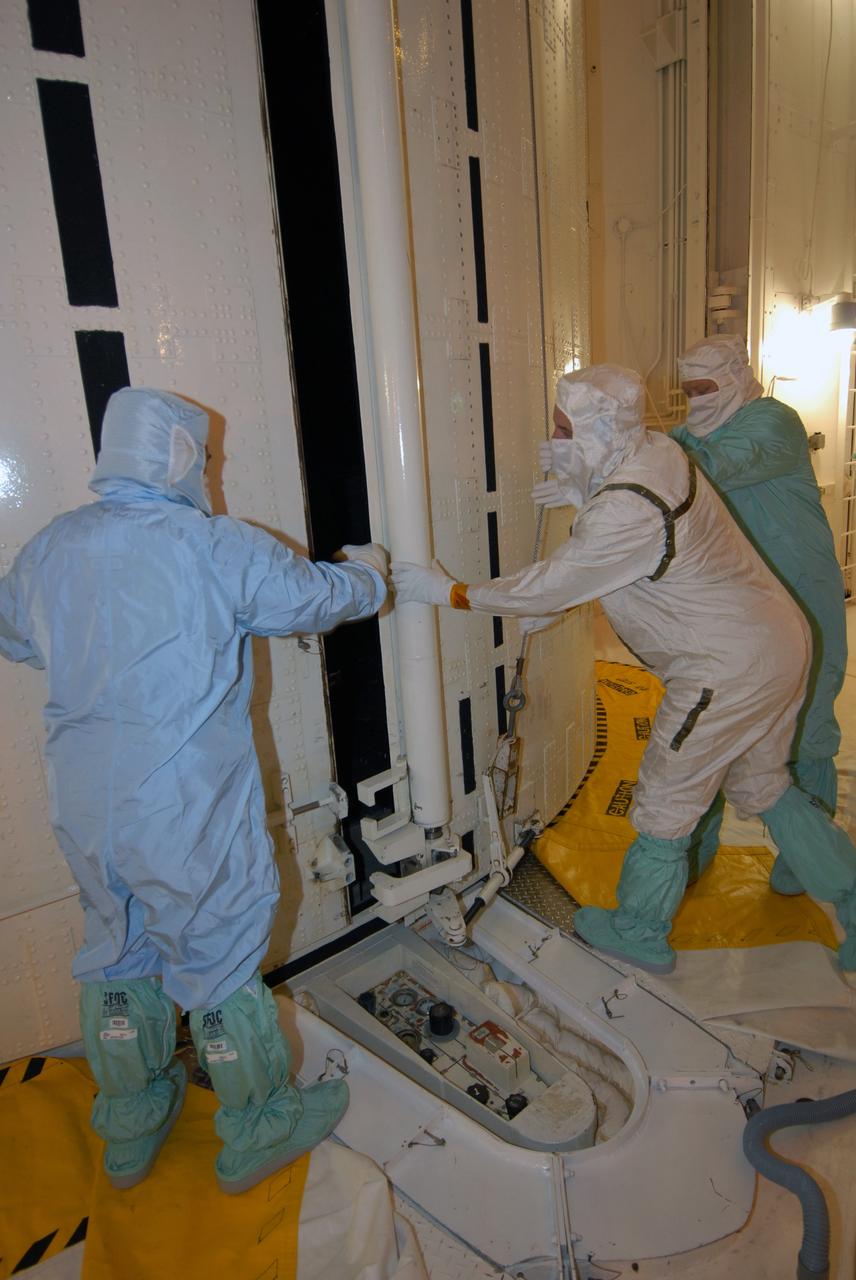 CAPE CANAVERAL, Fla. -  Inside the payload changeout room, or PCR, at NASA's Kennedy Space Center Launch Pad 39A, workers open the doors of the payload canister.  Inside are four carriers holding various equipment for the STS-125 mission aboard space shuttle Atlantis to service NASA’s Hubble Space Telescope. From top to bottom are the Multi-Use Logistic Equipment carrier, the Flight Support System carrier, the Orbital Replacment Unit Carrier and the Super Lightweight Interchangeable Carrier. The payload will be moved into the PCR. The PCR is the enclosed, environmentally controlled portion of the rotating service structure that supports cargo delivery to the pad and subsequent vertical installation into the shuttle’s payload bay. Launch of Atlantis is targeted for Oct. 10. Photo credit: NASA/Jack Pfaller