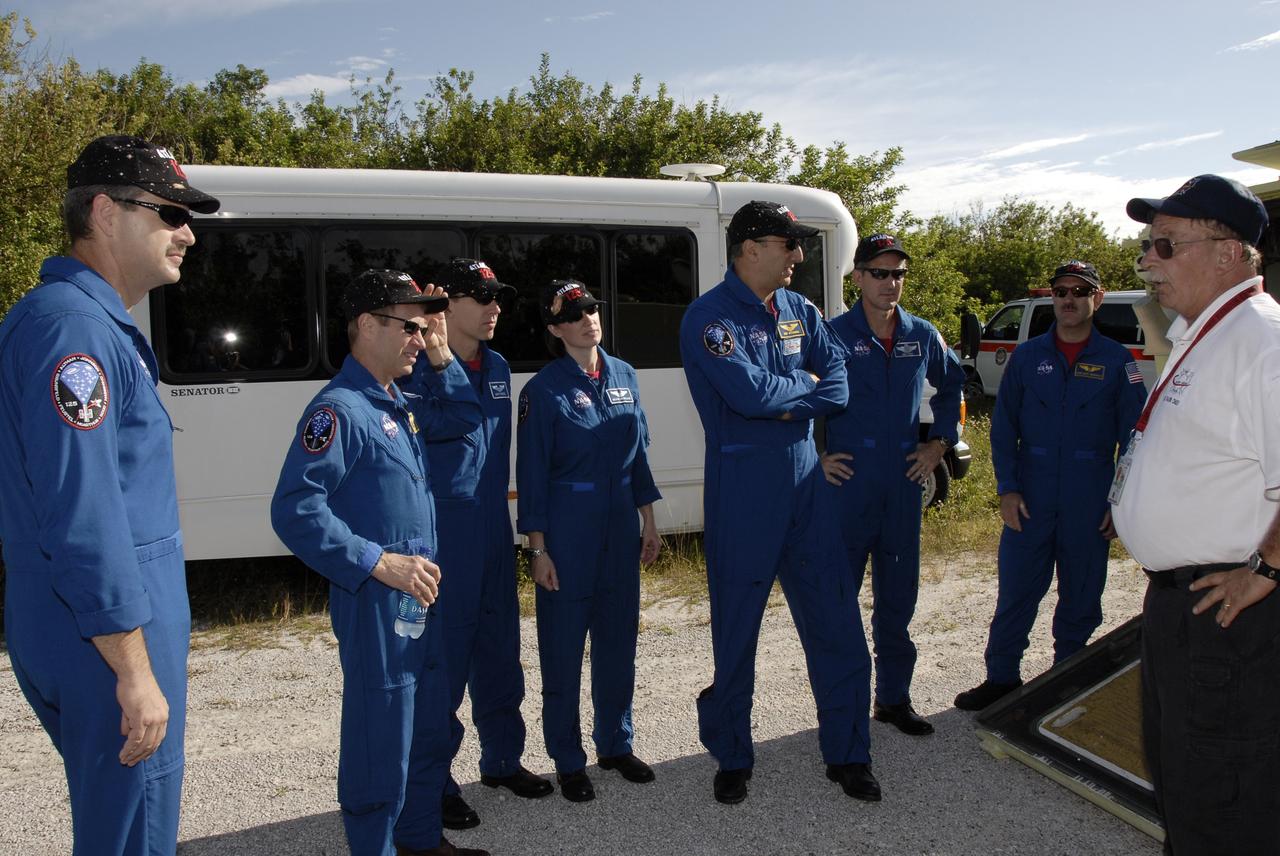 CAPE CANAVERAL, Fla. -  The STS-125 crew members listen to instructions for driving the M-113 armored personnel carrier.  From left are Commander Scott Altman, Pilot Gregory C. Johnson, Mission Specialists Andrew Feustel, Megan McArthur, Mike Massimino, Michael Good and John Grunsfeld. The crew members of space shuttle Atlantis' STS-125 mission will each practice driving the M-113 in turn as part of their training on emergency egress procedures. An M-113 will be available to transport the crew to safety in the event of a contingency on the pad before their launch. The crew is at NASA's Kennedy Space Center for a dress launch rehearsal called the terminal countdown demonstration test, or TCDT. It provides astronauts and ground crews with an opportunity to participate in various simulated countdown activities, including equipment familiarization,  emergency training and a simulated launch countdown. The STS-125 mission aboard space shuttle Atlantis to service NASA’s Hubble Space Telescope is targeted to launch Oct. 10.    Photo credit: NASA/Kim Shiflett