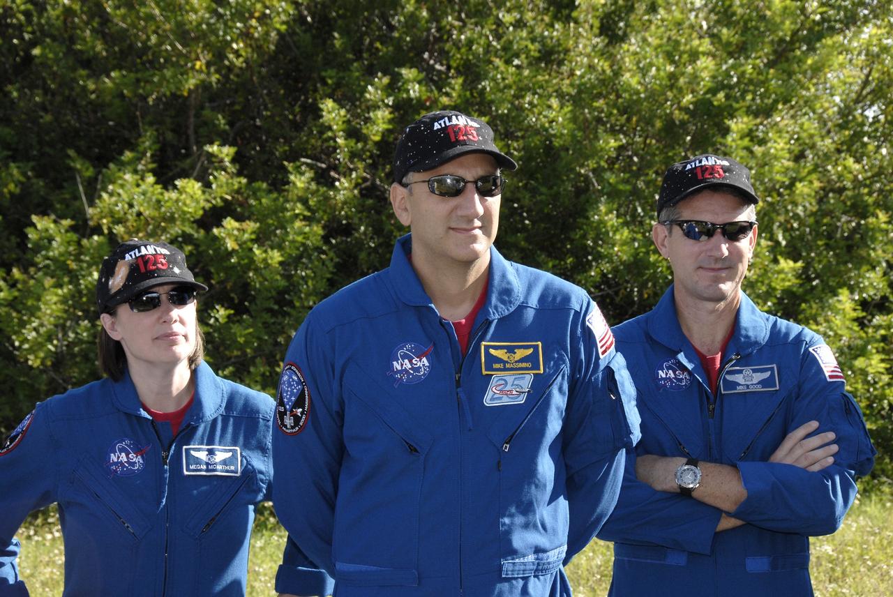 CAPE CANAVERAL, Fla. -  The STS-125 crew members listen to instructions for driving the M-113 armored personnel carrier.  From left are Mission Specialists Megan McArthur, Mike Massimino and Michael Good.  The crew members of space shuttle Atlantis' STS-125 mission will each practice driving the M-113 in turn as part of their training on emergency egress procedures. An M-113 will be available to transport the crew to safety in the event of a contingency on the pad before their launch. The crew is at NASA's Kennedy Space Center for a dress launch rehearsal called the terminal countdown demonstration test, or TCDT. It provides astronauts and ground crews with an opportunity to participate in various simulated countdown activities, including equipment familiarization,  emergency training and a simulated launch countdown. The STS-125 mission aboard space shuttle Atlantis to service NASA’s Hubble Space Telescope is targeted to launch Oct. 10.    Photo credit: NASA/Kim Shiflett