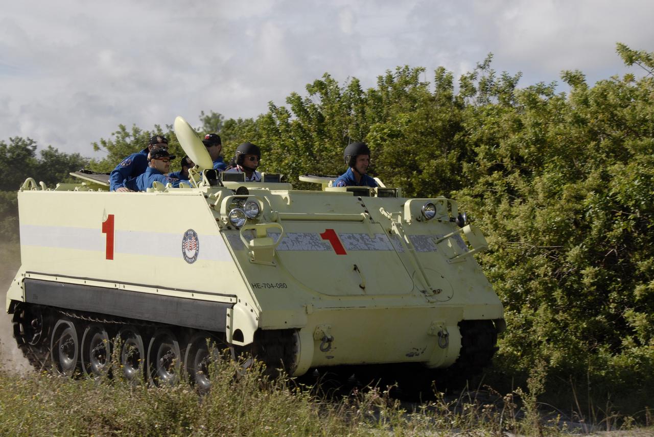 CAPE CANAVERAL, Fla. -  STS-125 Mission Specialist Michael Good practices driving the M-113 armored personnel carrier. Other crew members are behind him. The crew members of space shuttle Atlantis' STS-125 mission will each practice driving the M-113 in turn as part of their training on emergency egress procedures. An M-113 will be available to transport the crew to safety in the event of a contingency on the pad before their launch. The crew is at NASA's Kennedy Space Center for a dress launch rehearsal called the terminal countdown demonstration test, or TCDT. It provides astronauts and ground crews with an opportunity to participate in various simulated countdown activities, including equipment familiarization,  emergency training and a simulated launch countdown. The STS-125 mission aboard space shuttle Atlantis to service NASA’s Hubble Space Telescope is targeted to launch Oct. 10.    Photo credit: NASA/Kim Shiflett