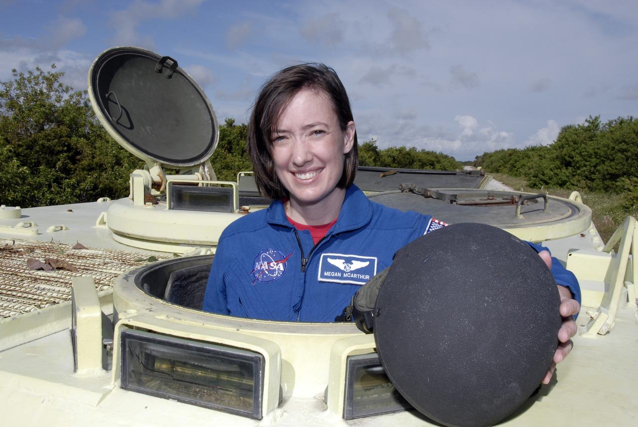 CAPE CANAVERAL, Fla. -  STS-125 Mission Specialist Megan McArthur is ready to practice driving the M-113 armored personnel carrier. The crew members of space shuttle Atlantis' STS-125 mission will each practice driving the M-113 in turn as part of their training on emergency egress procedures. An M-113 will be available to transport the crew to safety in the event of a contingency on the pad before their launch. The crew is at NASA's Kennedy Space Center for a dress launch rehearsal called the terminal countdown demonstration test, or TCDT. It provides astronauts and ground crews with an opportunity to participate in various simulated countdown activities, including equipment familiarization,  emergency training and a simulated launch countdown. The STS-125 mission aboard space shuttle Atlantis to service NASA’s Hubble Space Telescope is targeted to launch Oct. 10.    Photo credit: NASA/Kim Shiflett