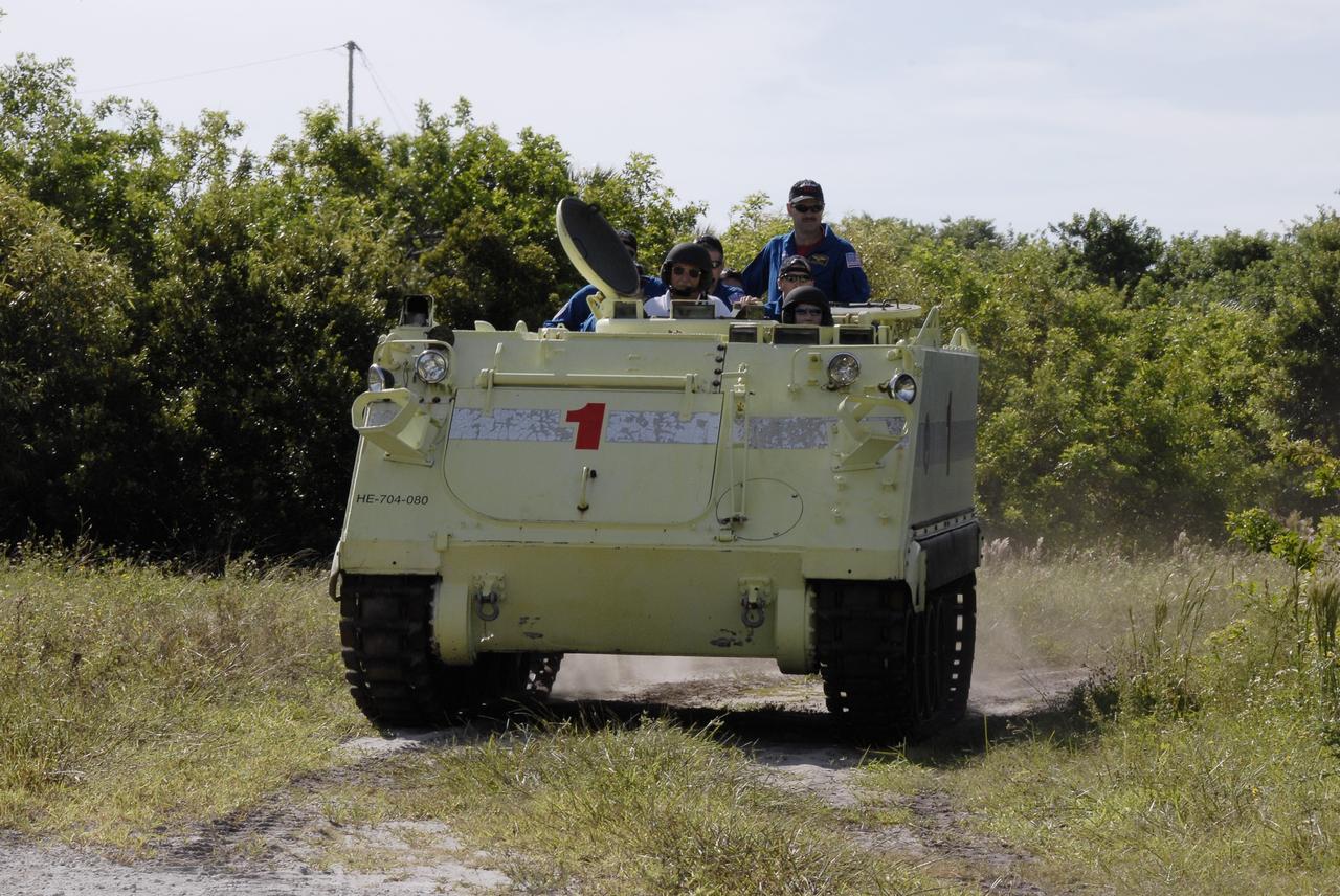 CAPE CANAVERAL, Fla. -  STS-125 Mission Specialist Megan McArthur practices driving the M-113 armored personnel carrier.  Other crew members are behind her. The crew members of space shuttle Atlantis' STS-125 mission will each practice driving the M-113 in turn as part of their training on emergency egress procedures. An M-113 will be available to transport the crew to safety in the event of a contingency on the pad before their launch. The crew is at NASA's Kennedy Space Center for a dress launch rehearsal called the terminal countdown demonstration test, or TCDT. It provides astronauts and ground crews with an opportunity to participate in various simulated countdown activities, including equipment familiarization,  emergency training and a simulated launch countdown. The STS-125 mission aboard space shuttle Atlantis to service NASA’s Hubble Space Telescope is targeted to launch Oct. 10.    Photo credit: NASA/Kim Shiflett
