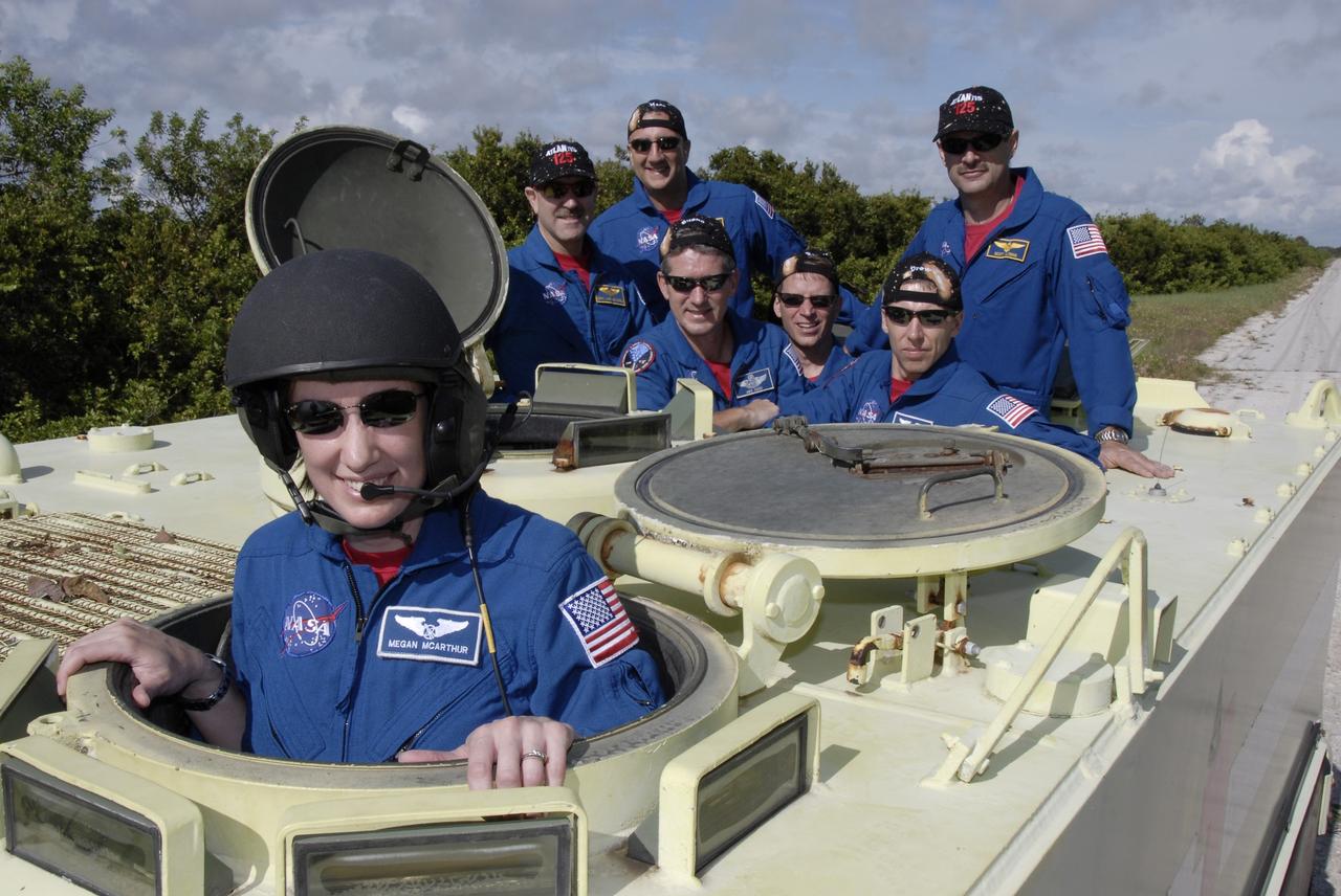 CAPE CANAVERAL, Fla. -  STS-125 Mission Specialist Megan McArthur successfully practiced driving the M-113 armored personnel carrier.  Other crew members behind her are Mission Specialist John Grunsfeld, Mike Massimino, Michael Good, Gregory C. Johnson, Andrew Feustel and Commander Scott Altman. The crew members of space shuttle Atlantis' STS-125 mission will each practice driving the M-113 in turn as part of their training on emergency egress procedures. An M-113 will be available to transport the crew to safety in the event of a contingency on the pad before their launch. The crew is at NASA's Kennedy Space Center for a dress launch rehearsal called the terminal countdown demonstration test, or TCDT. It provides astronauts and ground crews with an opportunity to participate in various simulated countdown activities, including equipment familiarization,  emergency training and a simulated launch countdown. The STS-125 mission aboard space shuttle Atlantis to service NASA’s Hubble Space Telescope is targeted to launch Oct. 10.    Photo credit: NASA/Kim Shiflett