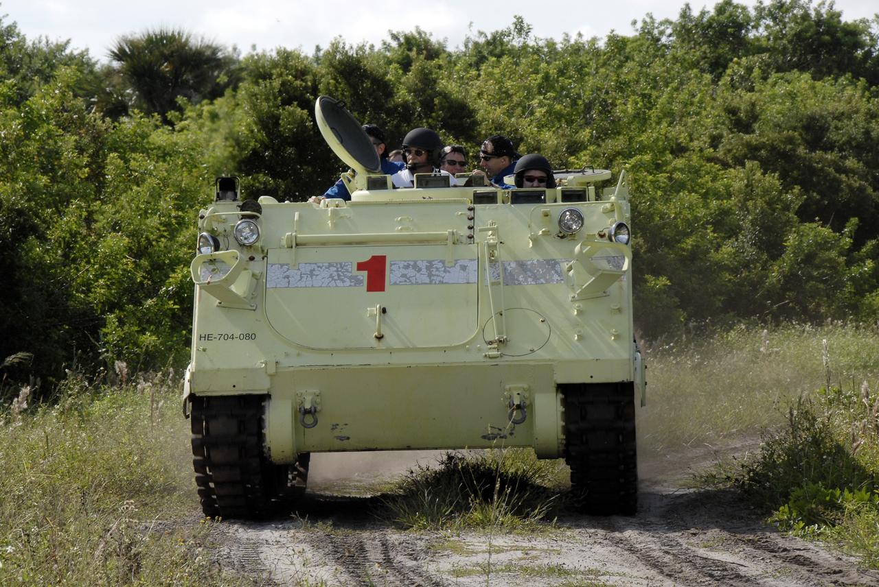 CAPE CANAVERAL, Fla. -  STS-125 Mission Specialist John Grunsfeld practices driving the M-113 armored personnel carrier.  Other crew members are behind him. The crew members of space shuttle Atlantis' STS-125 mission will each practice driving the M-113 in turn as part of their training on emergency egress procedures. An M-113 will be available to transport the crew to safety in the event of a contingency on the pad before their launch. The crew is at NASA's Kennedy Space Center for a dress launch rehearsal called the terminal countdown demonstration test, or TCDT. It provides astronauts and ground crews with an opportunity to participate in various simulated countdown activities, including equipment familiarization,  emergency training and a simulated launch countdown. The STS-125 mission aboard space shuttle Atlantis to service NASA’s Hubble Space Telescope is targeted to launch Oct. 10.    Photo credit: NASA/Kim Shiflett
