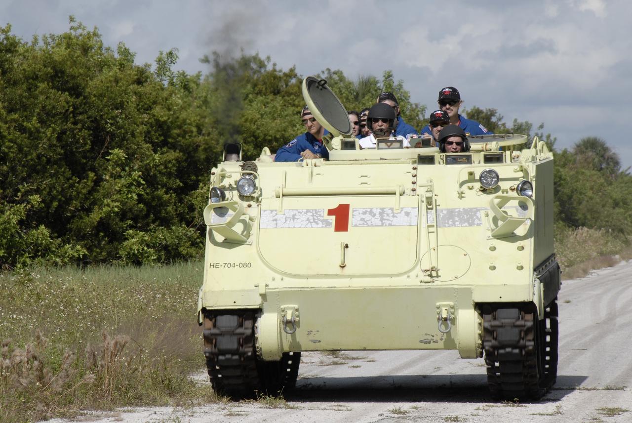 CAPE CANAVERAL, Fla. -  STS-125 Pilot Gregory C. Johnson practices driving the M-113 armored personnel carrier. Behind him are other crew members. The crew members of space shuttle Atlantis' STS-125 mission will each practice driving the M-113 in turn as part of their training on emergency egress procedures. An M-113 will be available to transport the crew to safety in the event of a contingency on the pad before their launch. The crew is at NASA's Kennedy Space Center for a dress launch rehearsal called the terminal countdown demonstration test, or TCDT. It provides astronauts and ground crews with an opportunity to participate in various simulated countdown activities, including equipment familiarization,  emergency training and a simulated launch countdown. The STS-125 mission aboard space shuttle Atlantis to service NASA’s Hubble Space Telescope is targeted to launch Oct. 10.    Photo credit: NASA/Kim Shiflett
