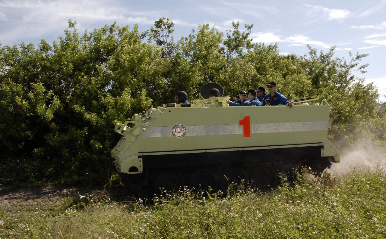 CAPE CANAVERAL, Fla. -  STS-125 Mission Specialist Mike Massimino practices driving the M-113 armored personnel carrier. Behind him are other crew members. The crew members of space shuttle Atlantis' STS-125 mission will each practice driving the M-113 in turn as part of their training on emergency egress procedures. An M-113 will be available to transport the crew to safety in the event of a contingency on the pad before their launch. The crew is at NASA's Kennedy Space Center for a dress launch rehearsal called the terminal countdown demonstration test, or TCDT. It provides astronauts and ground crews with an opportunity to participate in various simulated countdown activities, including equipment familiarization,  emergency training and a simulated launch countdown. The STS-125 mission aboard space shuttle Atlantis to service NASA’s Hubble Space Telescope is targeted to launch Oct. 10.    Photo credit: NASA/Kim Shiflett