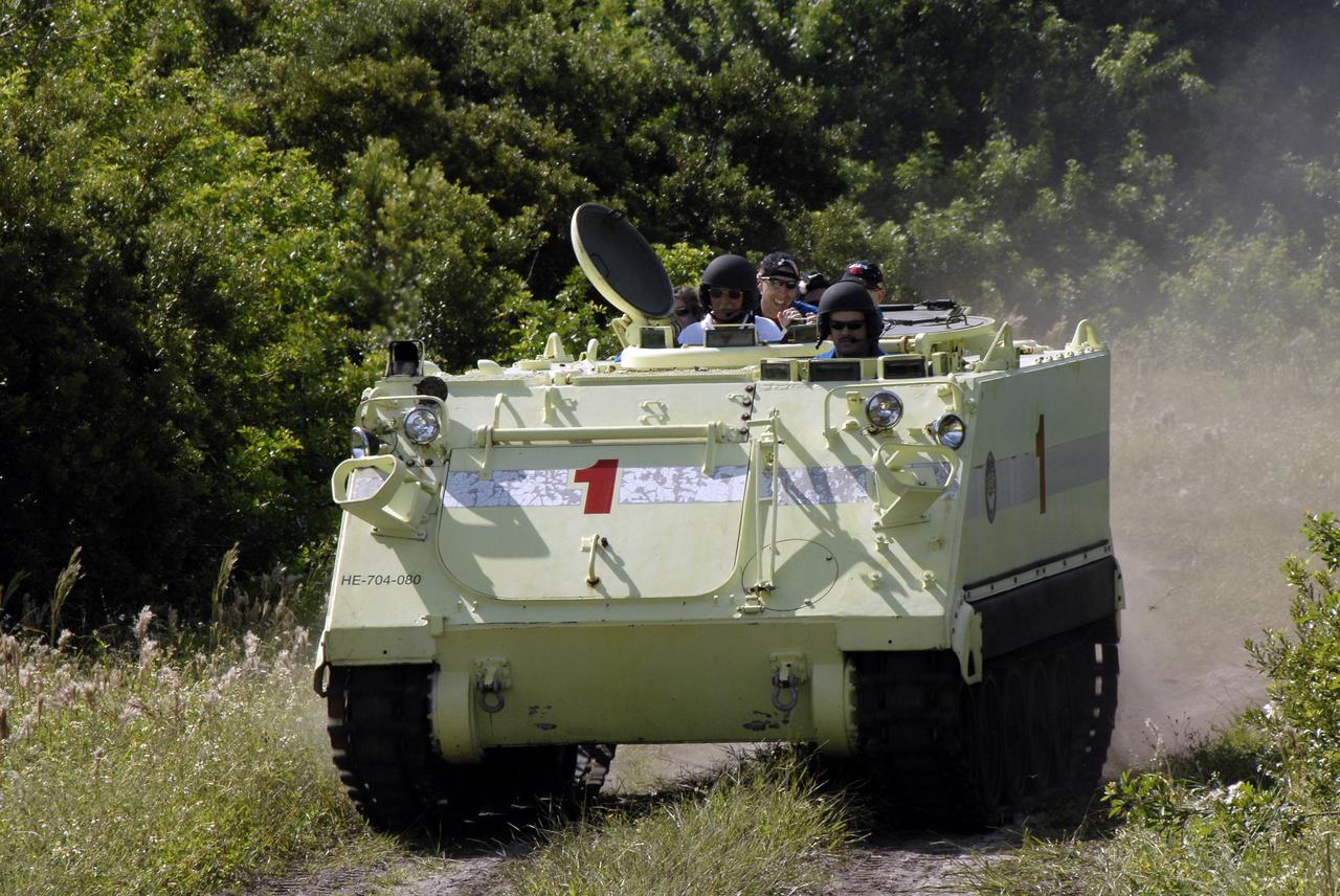 CAPE CANAVERAL, Fla. -  STS-125 Commander Scott Altman practices driving the M-113 armored personnel carrier. Behind him are other crew members.  The crew members of space shuttle Atlantis' STS-125 mission will each practice driving the M-113 in turn as part of their training on emergency egress procedures. An M-113 will be available to transport the crew to safety in the event of a contingency on the pad before their launch. The crew is at NASA's Kennedy Space Center for a dress launch rehearsal called the terminal countdown demonstration test, or TCDT. It provides astronauts and ground crews with an opportunity to participate in various simulated countdown activities, including equipment familiarization,  emergency training and a simulated launch countdown. The STS-125 mission aboard space shuttle Atlantis to service NASA’s Hubble Space Telescope is targeted to launch Oct. 10.    Photo credit: NASA/Kim Shiflett