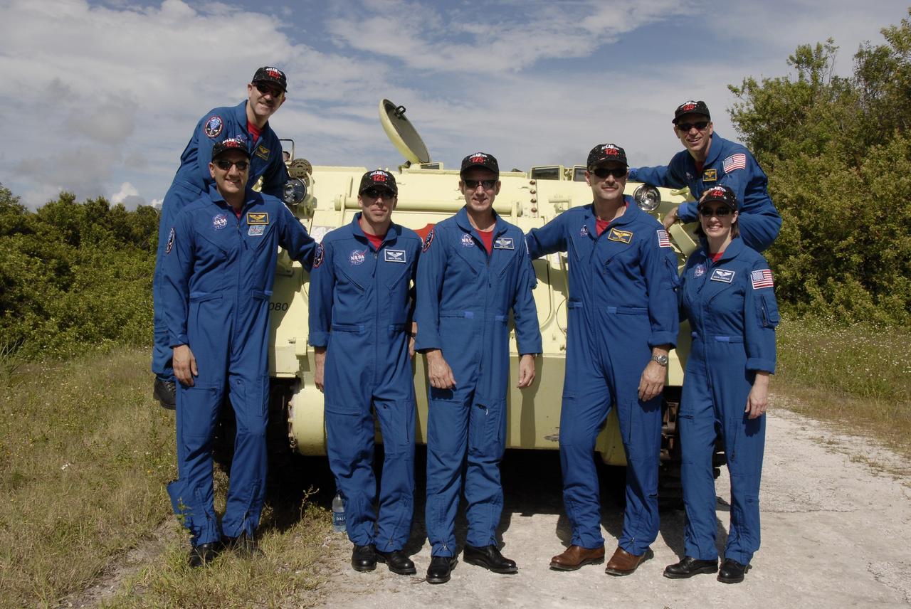 CAPE CANAVERAL, Fla. -  STS-125 crew members pause during training for a photo.  The crew has completed practice driving the M-113 armored personnel carrier.  From left are Mission Specialists John Grunsfeld (above), Mike Massimino, Andrew Feustel, Michael Good, Commander Scott Altman, Mission Specialist Megan McArthur and Pilot Gregory C. Johnson. The crew members of space shuttle Atlantis' STS-125 mission each practiced driving the M-113 in turn as part of their training on emergency egress procedures. An M-113 will be available to transport the crew to safety in the event of a contingency on the pad before their launch. The crew is at NASA's Kennedy Space Center for a dress launch rehearsal called the terminal countdown demonstration test, or TCDT. It provides astronauts and ground crews with an opportunity to participate in various simulated countdown activities, including equipment familiarization,  emergency training and a simulated launch countdown. The STS-125 mission aboard space shuttle Atlantis to service NASA’s Hubble Space Telescope is targeted to launch Oct. 10.    Photo credit: NASA/Kim Shiflett