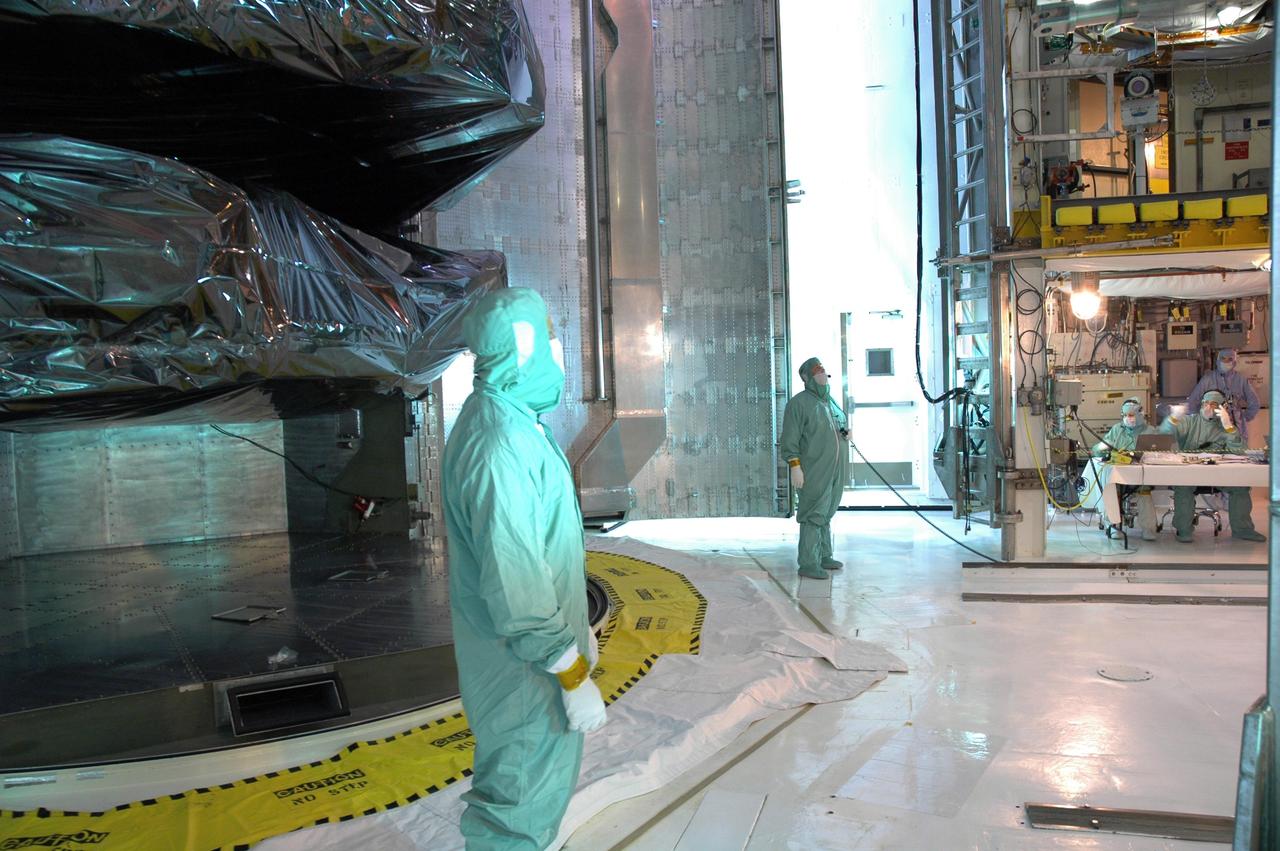 CAPE CANAVERAL, Fla. -  In the payload changeout room, or PCR, on Launch Pad 39A at NASA's Kennedy Space Center in Florida, workers prepare for the transfer of the cargo inside the payload canister, at left.  Two of the four carriers seen behind the workers are the Orbital Replacement Unit Carrier (top) and the Super Lightweight Interchangeable Carrier.  The cargo will be transferred into the PCR via the payload ground-handling mechanism, or PGHM.  The PGHM removes payloads from a transportation canister and installs them into the shuttle. It is essentially NASA’s largest fork-lift.  Atlantis is targeted to launch Oct. 10.  Photo credit: NASA/Jim Grossmann