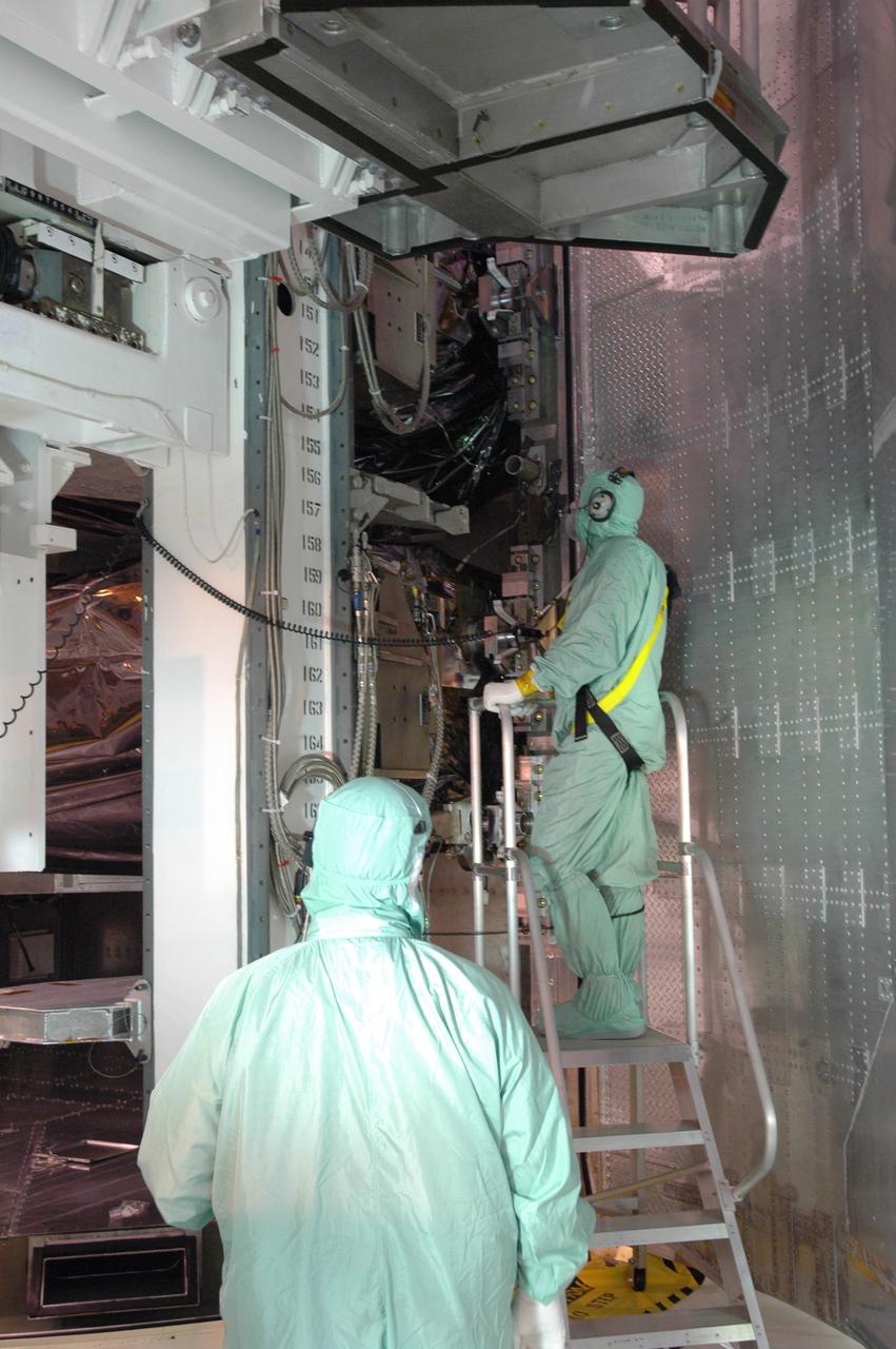 CAPE CANAVERAL, Fla. -  In the payload changeout room, or PCR, on Launch Pad 39A at NASA's Kennedy Space Center in Florida,  workers make small adjustments to the payload ground-handling mechanism, or PGHM, that will remove the cargo from the payload canister. The cargo comprises four carriers holding various equipment for the STS-125 mission aboard space shuttle Atlantis to service NASA’s Hubble Space Telescope. The PGHM removes payloads from a transportation canister and installs them into the shuttle. It is essentially NASA’s largest fork-lift.  Atlantis is targeted to launch Oct. 10.  Photo credit: NASA/Jim Grossmann