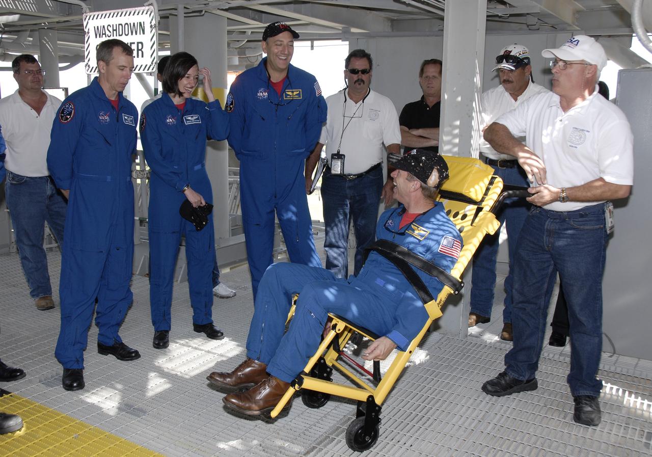 CAPE CANAVERAL, Fla. -   STS-125 Pilot Gregory C. Johnson serves as a “guinea pig” to demonstrate emergency escape apparatus from the 195-foot level of the fixed service structure on Launch Pad 39A at NASA's Kennedy Space Center in Florida.  Looking on are Mission Specialists Andrew Feustel, Megan McArthur and Mike Massimino. The crew is at Kennedy to take part in terminal countdown demonstration test, or TCDT, activities before launching on space shuttle Atlantis’ mission to service NASA’s Hubble Space Telescope. TCDT provides astronauts and ground crews with an opportunity to participate in various simulated countdown activities, including equipment familiarization, emergency training and a simulated launch countdown. Atlantis is targeted to launch Oct. 10. Photo credit: NASA/Kim Shiflett