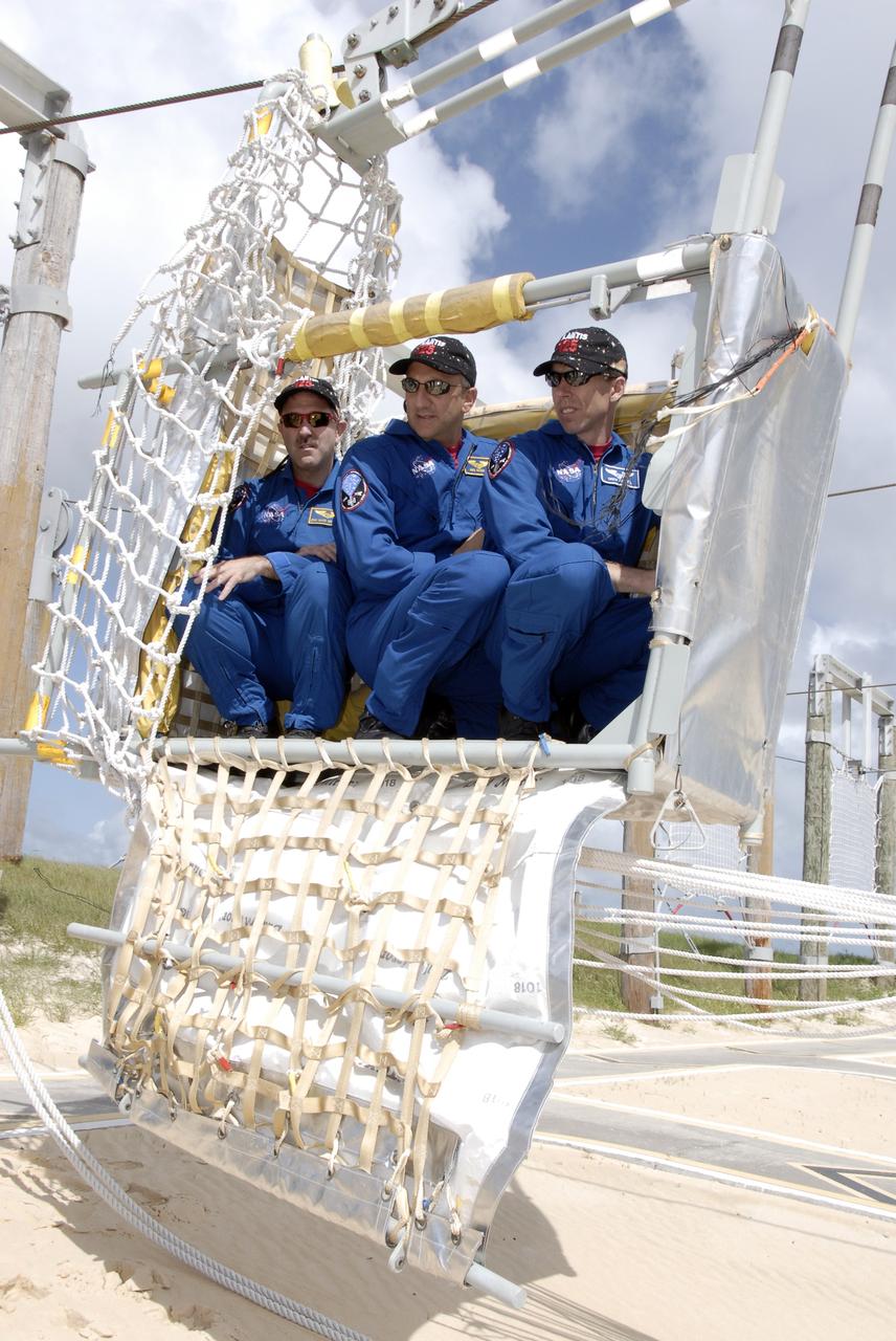 CAPE CANAVERAL, Fla. - STS-125 crew members are ready to practice climbing out of the slidewire baskets used during emergency escape procedures from the shuttle and pad. From left are Mission Specialists John Grunsfeld, Mike Massimino and Andrew Feustel. The crew is at Kennedy to take part in terminal countdown demonstration test, or TCDT, activities before launching on space shuttle Atlantis’ mission to service NASA’s Hubble Space Telescope. TCDT provides astronauts and ground crews with an opportunity to participate in various simulated countdown activities, including equipment familiarization, emergency training and a simulated launch countdown. Atlantis is targeted to launch Oct. 10. Photo credit: NASA/Kim Shiflett