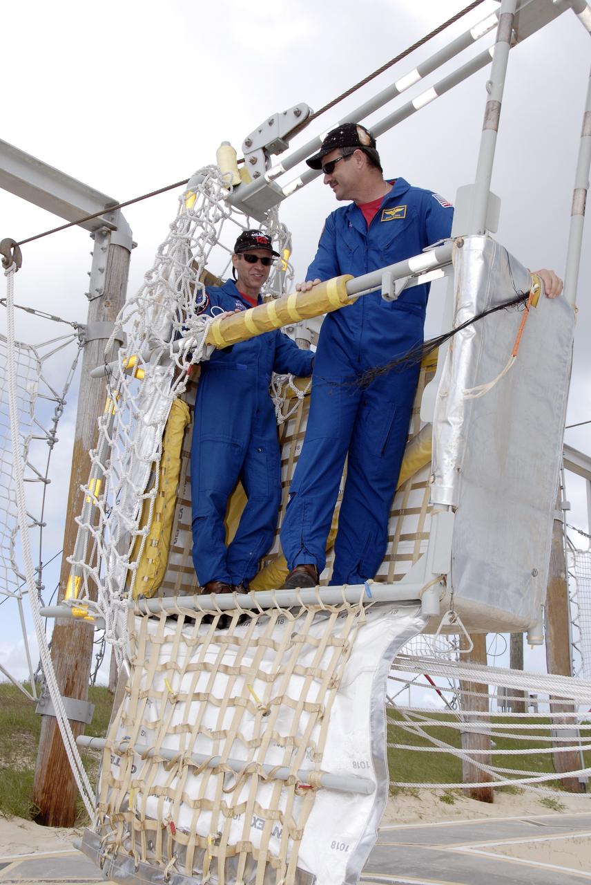 CAPE CANAVERAL, Fla. -    STS-125 crew members are ready to practice climbing out of the slidewire baskets used during emergency escape procedures from the shuttle and pad. From left are Pilot Gregory C. Johnson and Commander Scott Altman. The crew is at Kennedy to take part in terminal countdown demonstration test, or TCDT, activities before launching on space shuttle Atlantis’ mission to service NASA’s Hubble Space Telescope. TCDT provides astronauts and ground crews with an opportunity to participate in various simulated countdown activities, including equipment familiarization, emergency training and a simulated launch countdown. Atlantis is targeted to launch Oct. 10. Photo credit: NASA/Kim Shiflett