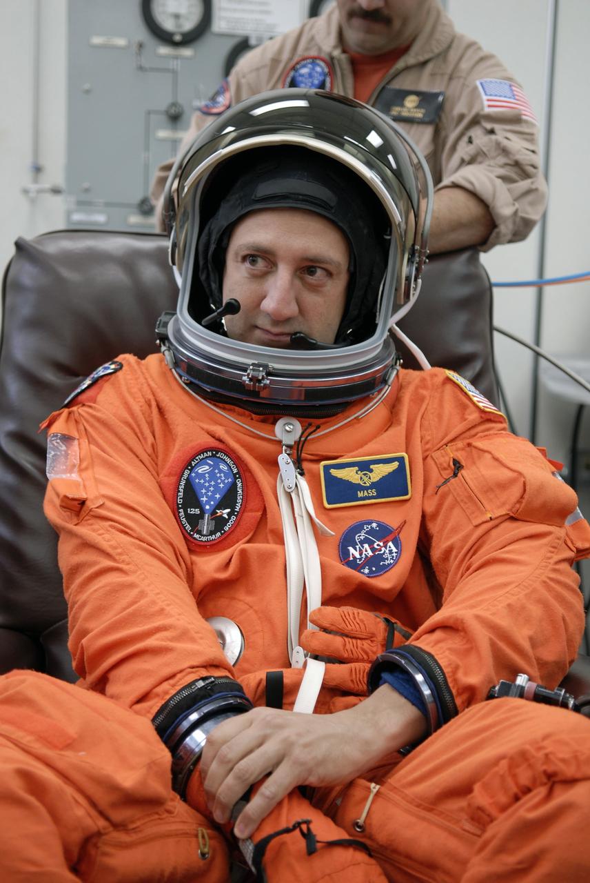 CAPE CANAVERAL, Fla. - STS-125 Mission Specialist Mike Massimino tries on his helmet to check the fit. Massimino will be making is second shuttle launch. His name patch reflects the nicknames the crew gave each other. The crew is at NASA's Kennedy Space Center in Florida to take part in terminal countdown demonstration test, or TCDT, activities as preparation before launch on space shuttle Atlantis’ STS-125 mission to service NASA’s Hubble Space Telescope. TCDT provides astronauts and ground crews with an opportunity to participate in various simulated countdown activities, including equipment familiarization, emergency training and a launch countdown. Atlantis is targeted to launch Oct. 14. Photo credit: NASA/Kim Shiflett