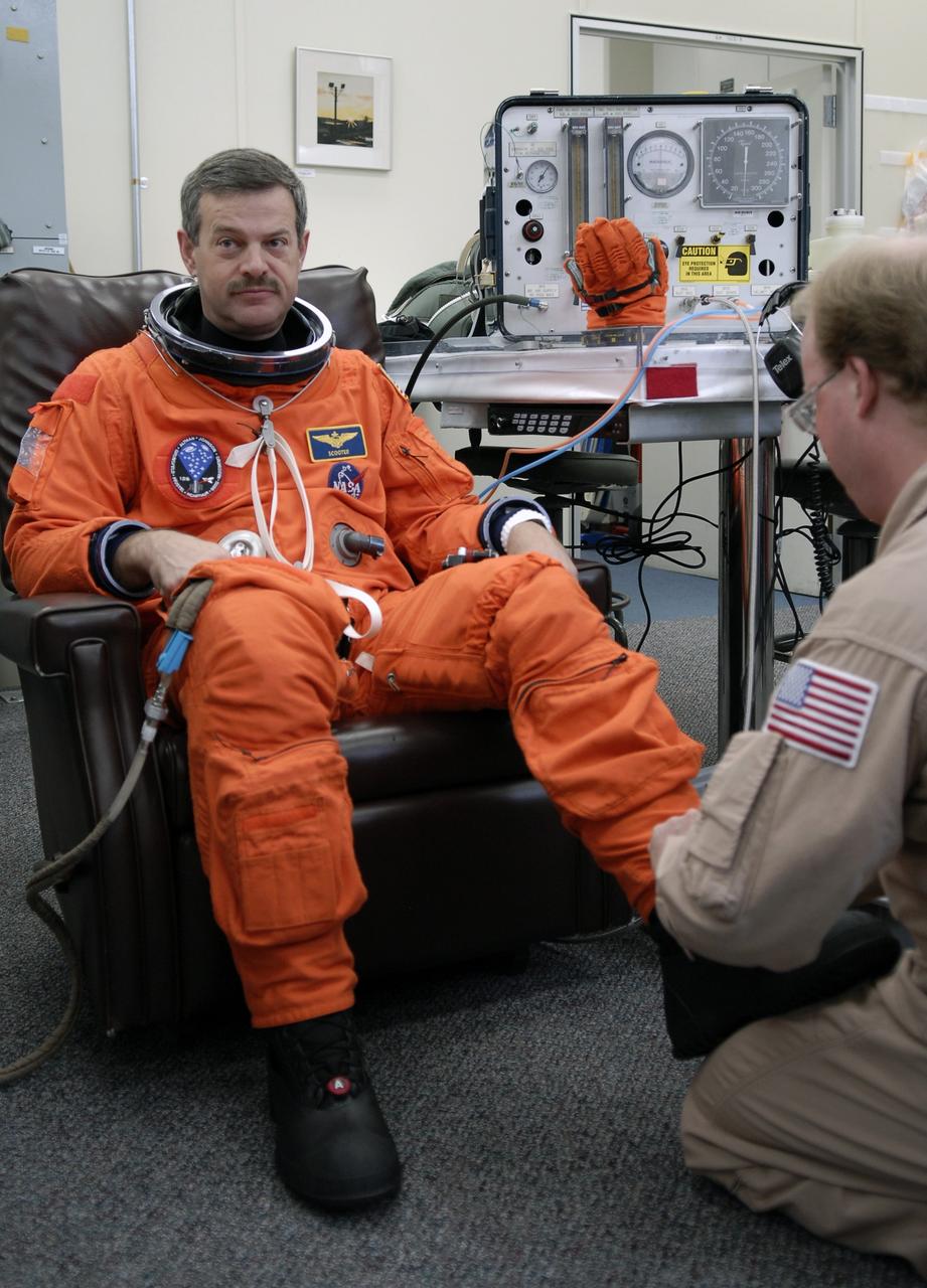 CAPE CANAVERAL, Fla. -  A technician checks STS-125 Commander Scott Altman’s boot as part of his launch-and-entry suit.  A veteran in space, Altman will be making his fourth shuttle launch. His name patch reflects his military “call sign.”  The crew is at NASA's Kennedy Space Center in Florida to take part in terminal countdown demonstration test, or TCDT, activities as preparation before launch on space shuttle Atlantis’ STS-125 mission to service NASA’s Hubble Space Telescope. TCDT provides astronauts and ground crews with an opportunity to participate in various simulated countdown activities, including equipment familiarization, emergency training and a launch countdown. Atlantis is targeted to launch Oct. 14. Photo credit: NASA/Kim Shiflett