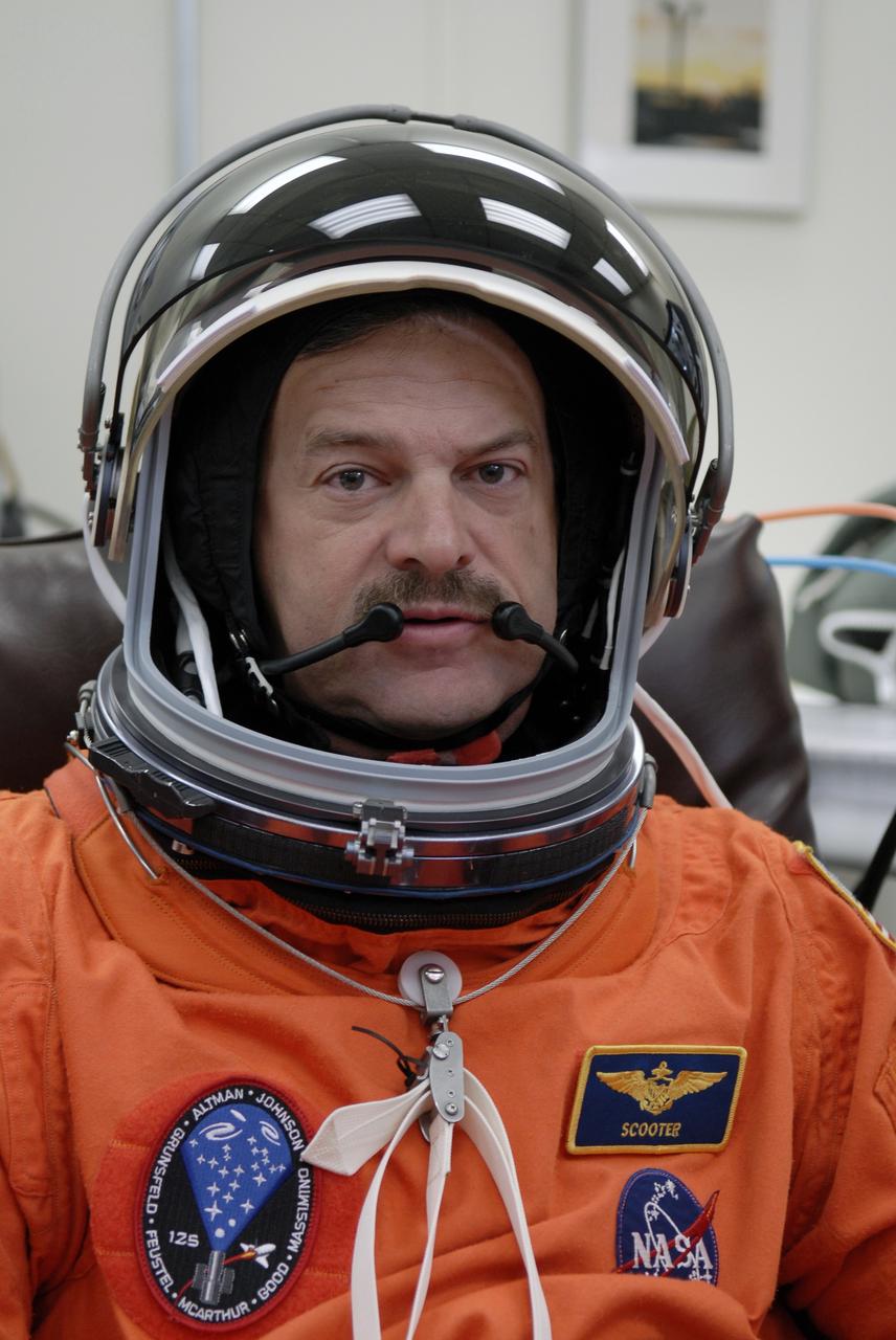 CAPE CANAVERAL, Fla. - STS-125 Commander Scott Altman tries on his helmet for a fit check. A veteran in space, Altman will be making his fourth shuttle launch. His name patch reflects his military “call sign.” The crew is at NASA's Kennedy Space Center in Florida to take part in terminal countdown demonstration test, or TCDT, activities as preparation before launch on space shuttle Atlantis’ STS-125 mission to service NASA’s Hubble Space Telescope. TCDT provides astronauts and ground crews with an opportunity to participate in various simulated countdown activities, including equipment familiarization, emergency training and a launch countdown. Atlantis is targeted to launch Oct. 14. Photo credit: NASA/Kim Shiflett