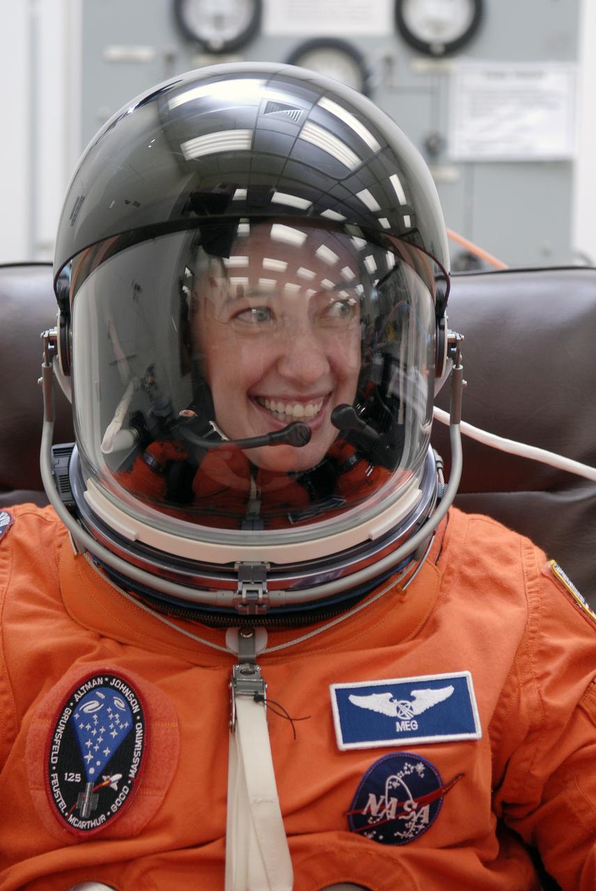 CAPE CANAVERAL, Fla. - STS-125 Mission Specialist Megan McArthur tries on her helmet for a fit check. McArthur will be making her first shuttle launch. Her name patch reflects the nicknames the crew gave each other. The crew is at NASA's Kennedy Space Center in Florida to take part in terminal countdown demonstration test, or TCDT, activities as preparation before launch on space shuttle Atlantis’ STS-125 mission to service NASA’s Hubble Space Telescope. TCDT provides astronauts and ground crews with an opportunity to participate in various simulated countdown activities, including equipment familiarization, emergency training and a launch countdown. Atlantis is targeted to launch Oct. 14. Photo credit: NASA/Kim Shiflett