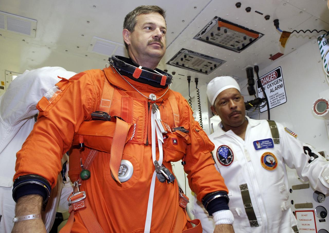 CAPE CANAVERAL, Fla. - STS-125 Commander Scott Altman is helped by a suit technician to don a harness over his launch and entry suit before entering space shuttle Atlantis for a simulated launch countdown. The countdown is the culmination of terminal countdown demonstration test, or TCDT, activities as preparation before launch. TCDT provides astronauts and ground crews with an opportunity to participate in various launch activities, including equipment familiarization, emergency training and the countdown. Atlantis’ STS-125 mission to service NASA’s Hubble Space Telescope is targeted for launch Oct. 14. Photo credit: NASA/Amanda Diller